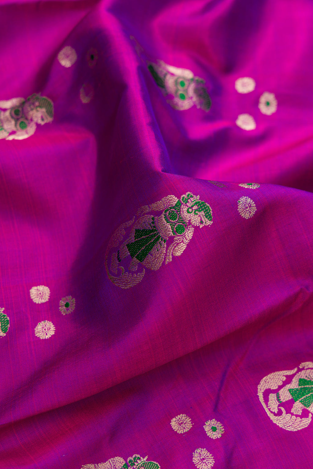 Close up of Pure Silk Magenta Dual Tone Baluchari Saree with Zari And Thread Butta on the body and Fancy Border.  displaying folds