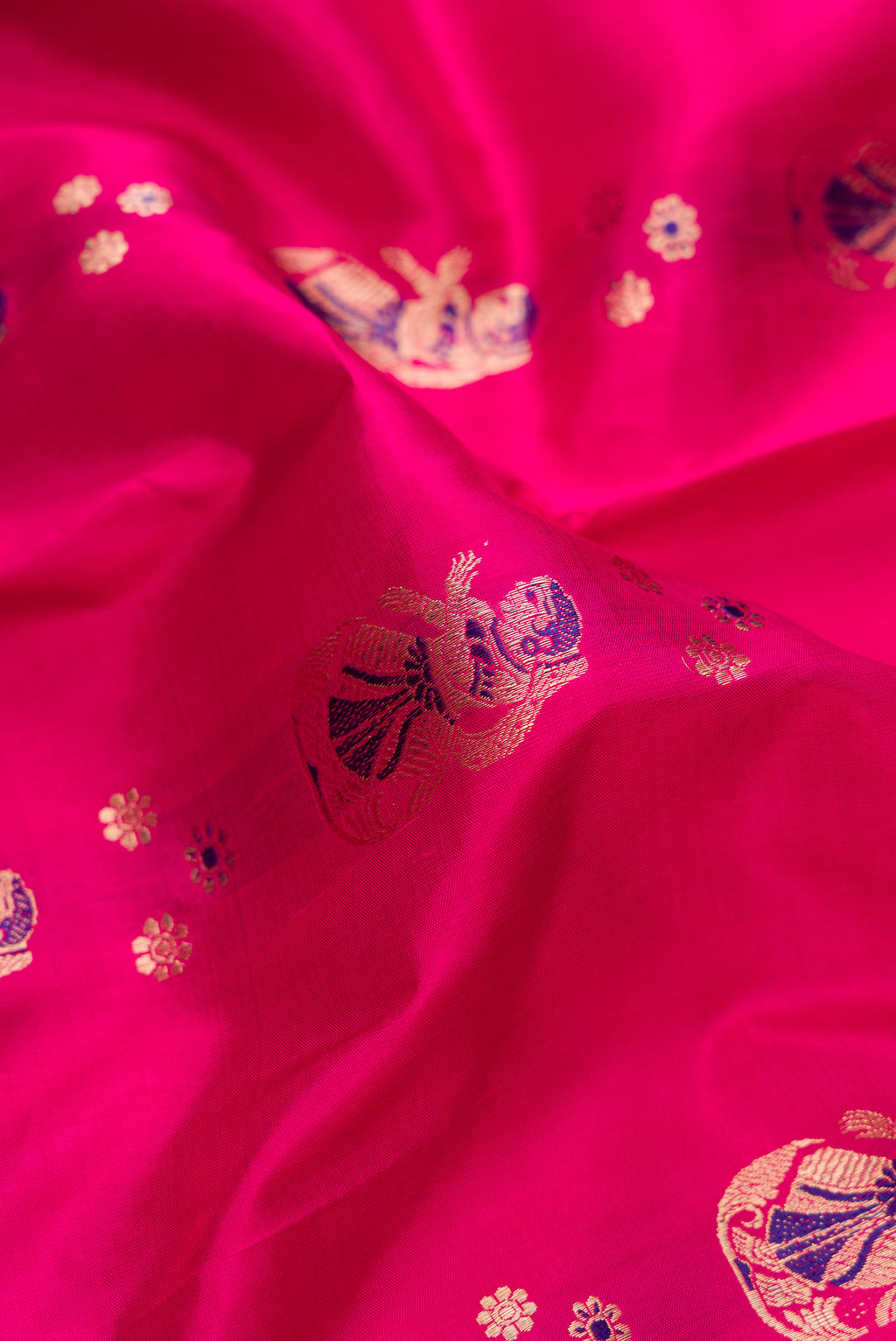 Close up of Pure Silk Dark Pink Dual Tone Baluchari Saree with Zari And Thread Butta on the body and Fancy Border.  displaying folds