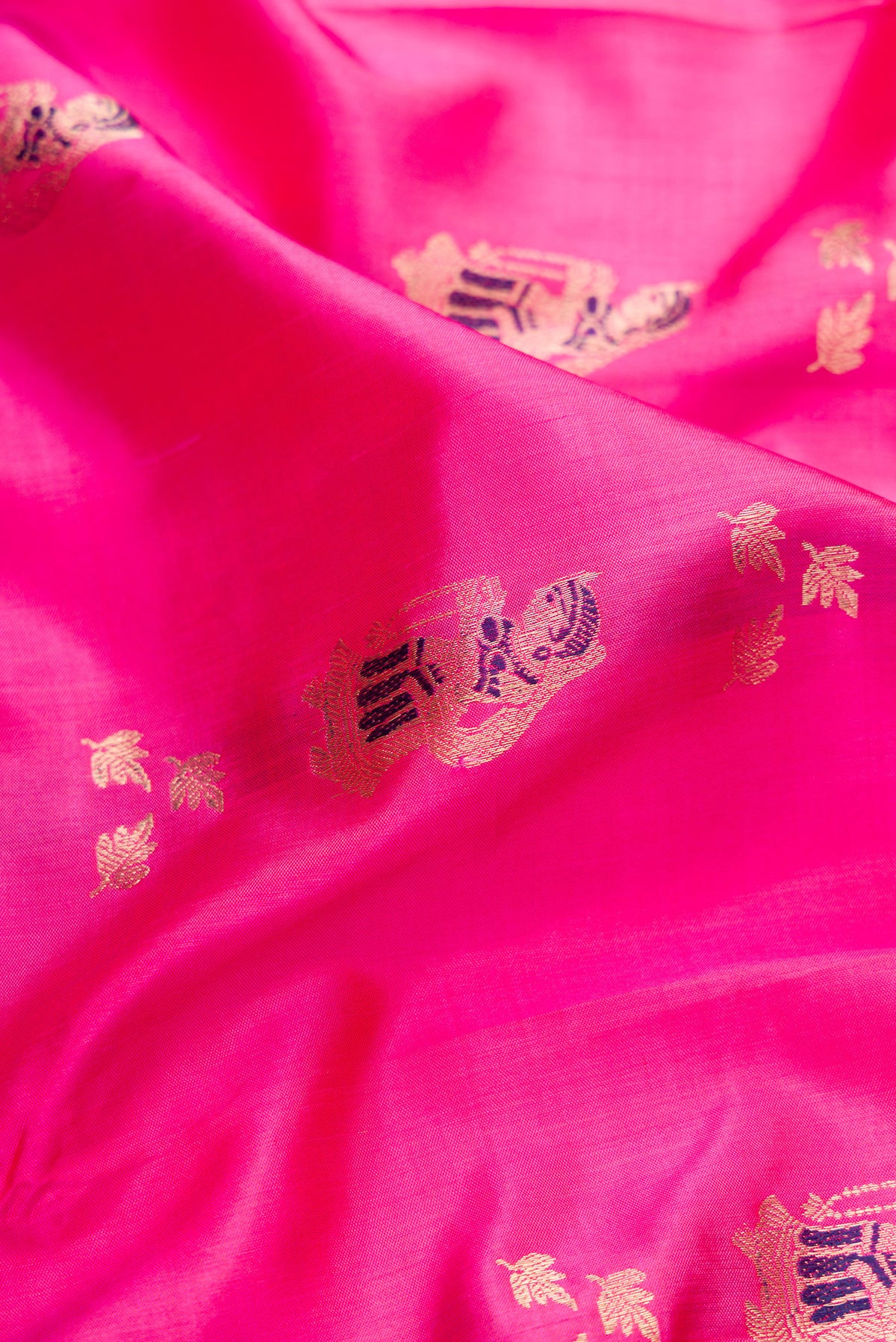 Close up of Pure Silk Pink Baluchari Saree with Zari And Thread Butta on the body and Fancy Border.  displaying folds