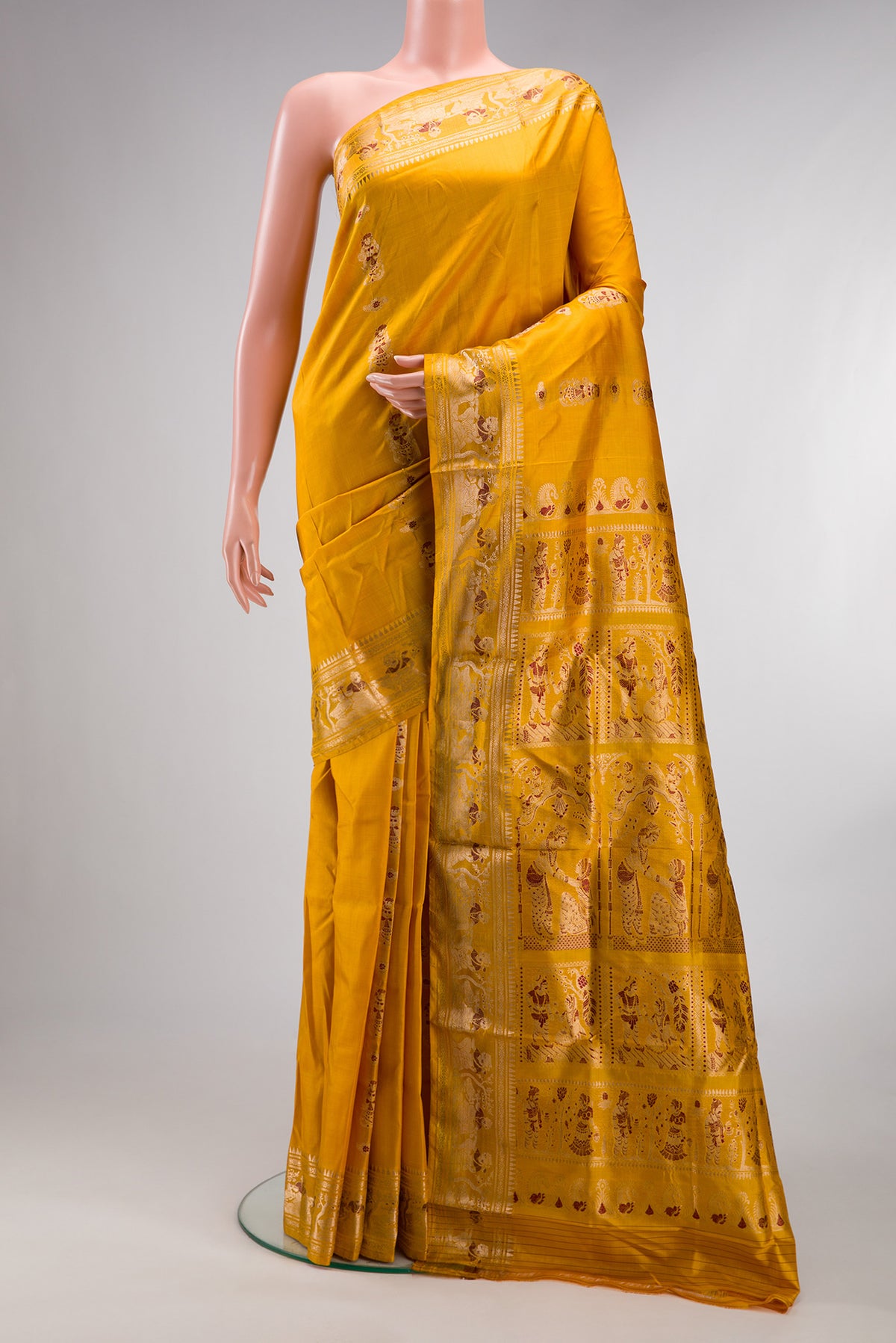 Pure Silk Mustard Baluchari Saree with Zari And Thread Butta on the body and Fancy Border.  displayed on a mannequin