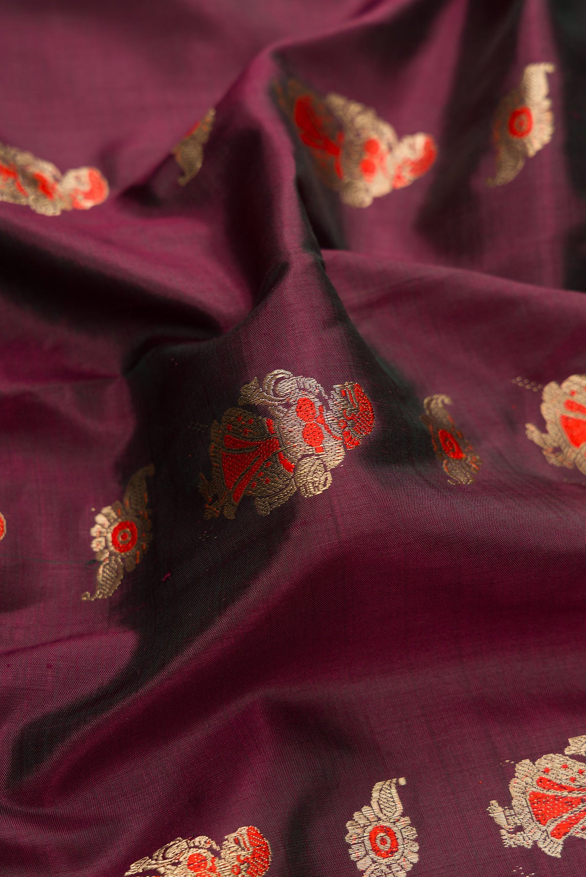 Close up of Pure Silk Coffee Brown Baluchari Saree with Zari And Thread Butta on the body and Fancy Border.  displaying folds