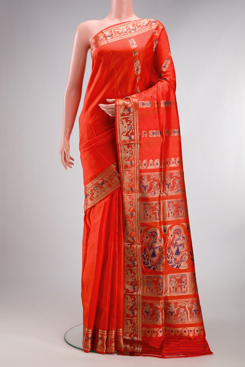 Pure Silk Orange Baluchari Saree with Zari And Thread Butta on the body and Fancy Border.  displayed on a mannequin