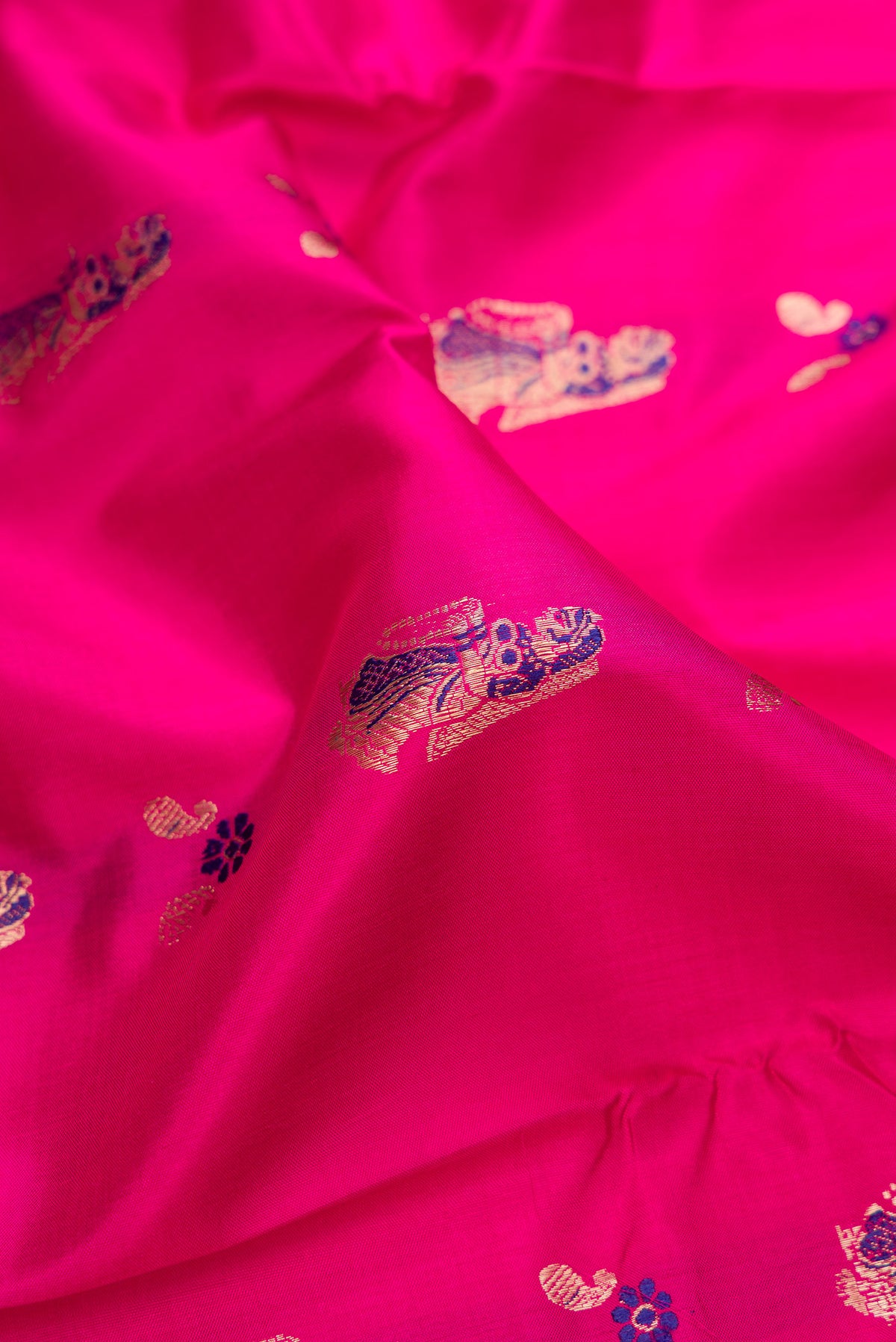 Close up of Pure Silk Pink Baluchari Saree with Zari And Thread Butta on the body and Fancy Border.  displaying folds