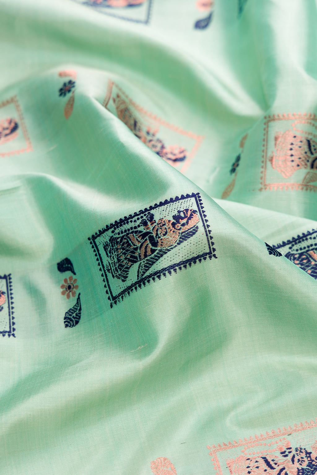 Close up of Pure Silk Pista Green Baluchari Saree with Zari And Thread Butta on the body and Fancy Border.  displaying folds
