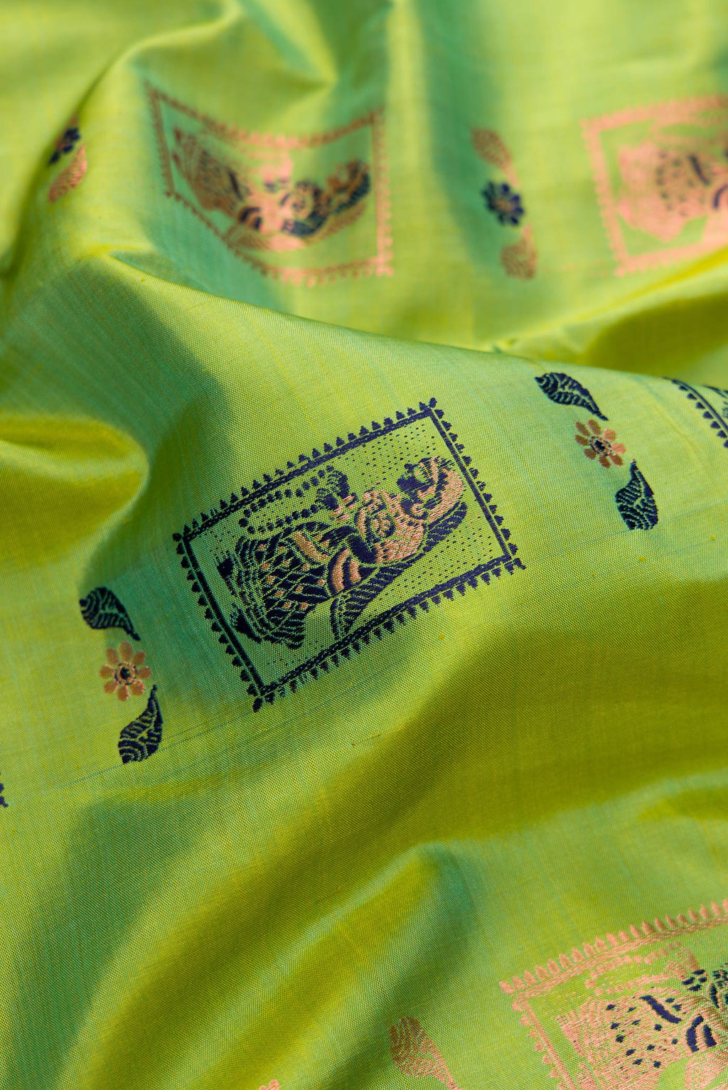 Close up of Pure Silk Parrot Green Dual Tone Baluchari Saree with Zari And Thread Butta on the body and Fancy Border.  displaying folds