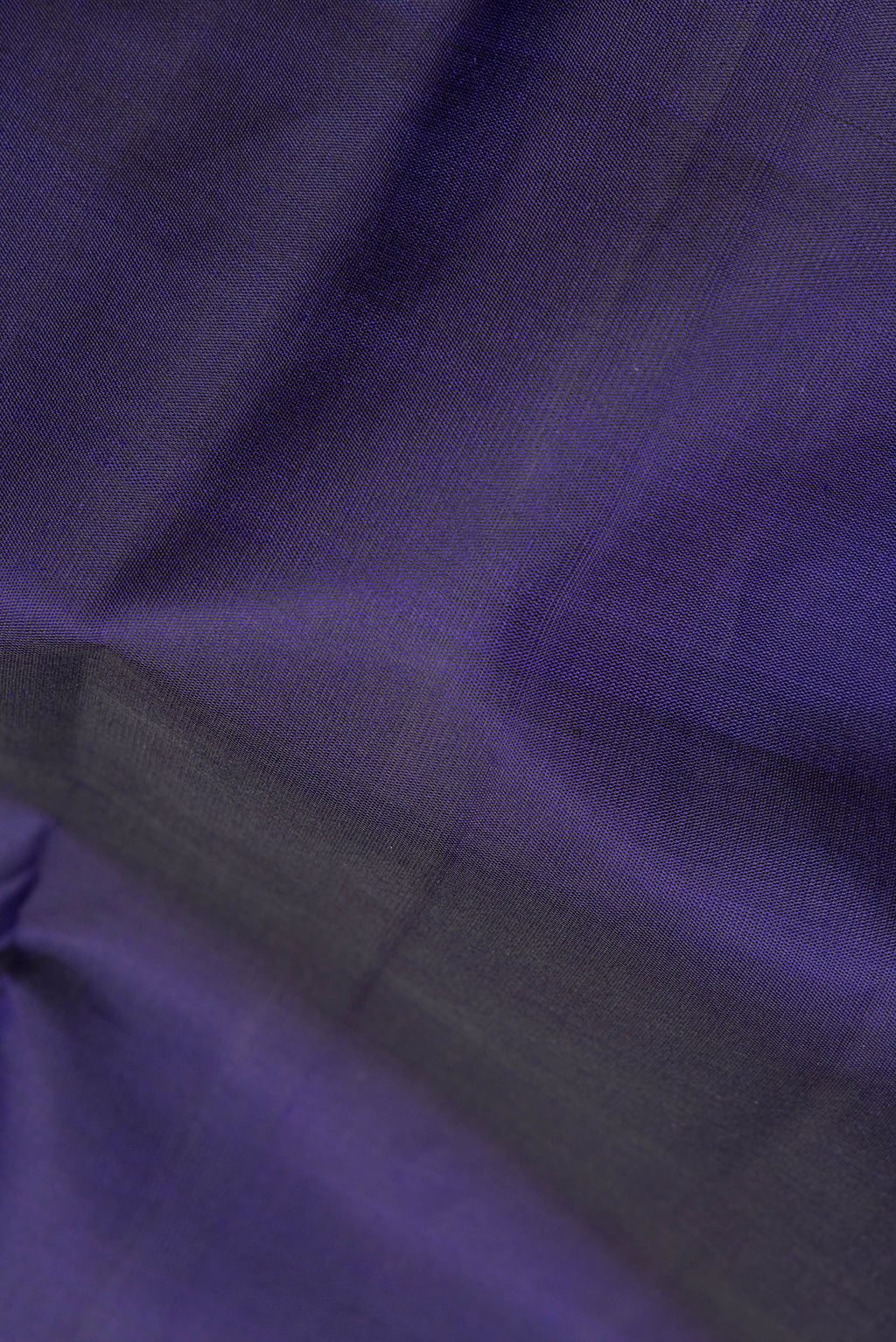 Close up of Pure Silk Navy Blue Dual Tone Kanjivaram Saree with Plain Body and Zari Border.  displaying folds