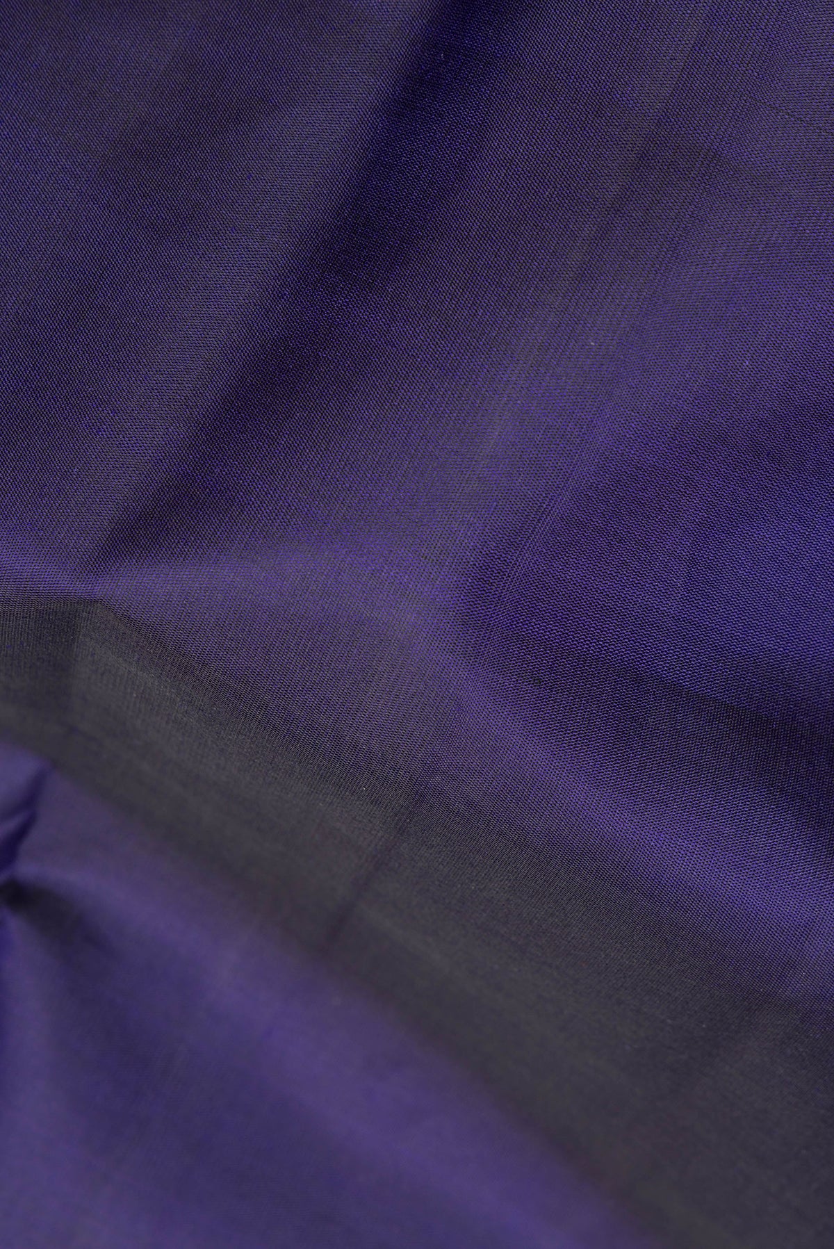 Close up of Pure Silk Navy Blue Dual Tone Kanjivaram Saree with Plain Body and Zari Border.  displaying folds