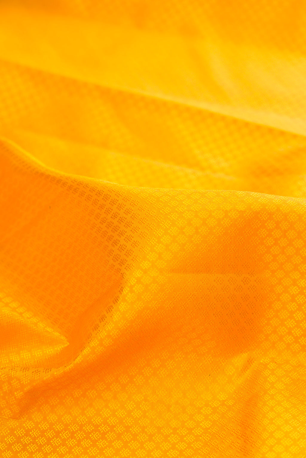 Close up of Pure Silk Yellow Kanjivaram Saree with Jacquard design on the body and Zari Border.  displaying folds