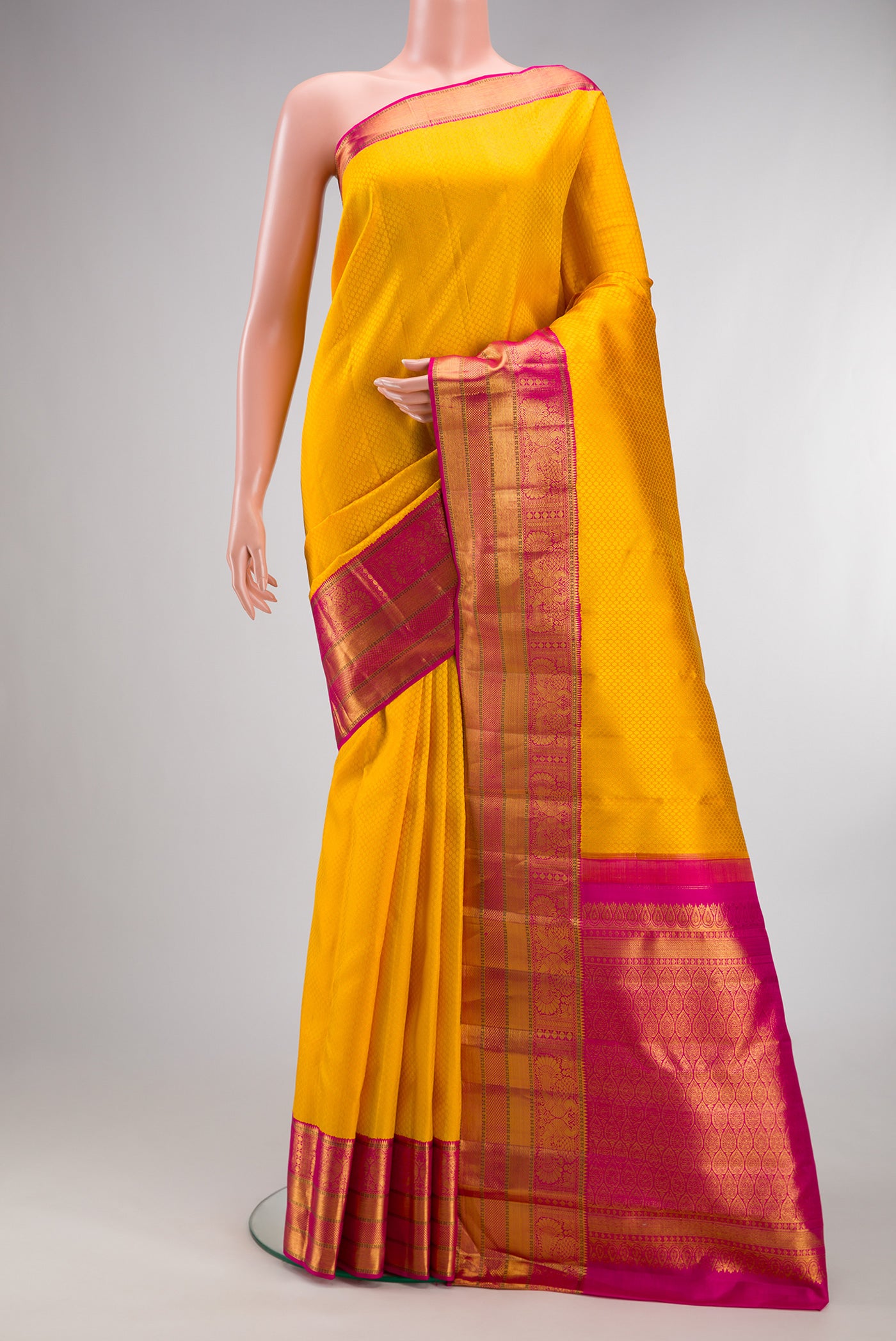 Pure Silk Yellow Kanjivaram Saree with Jacquard design on the body and Zari Border.  displayed on a mannequin