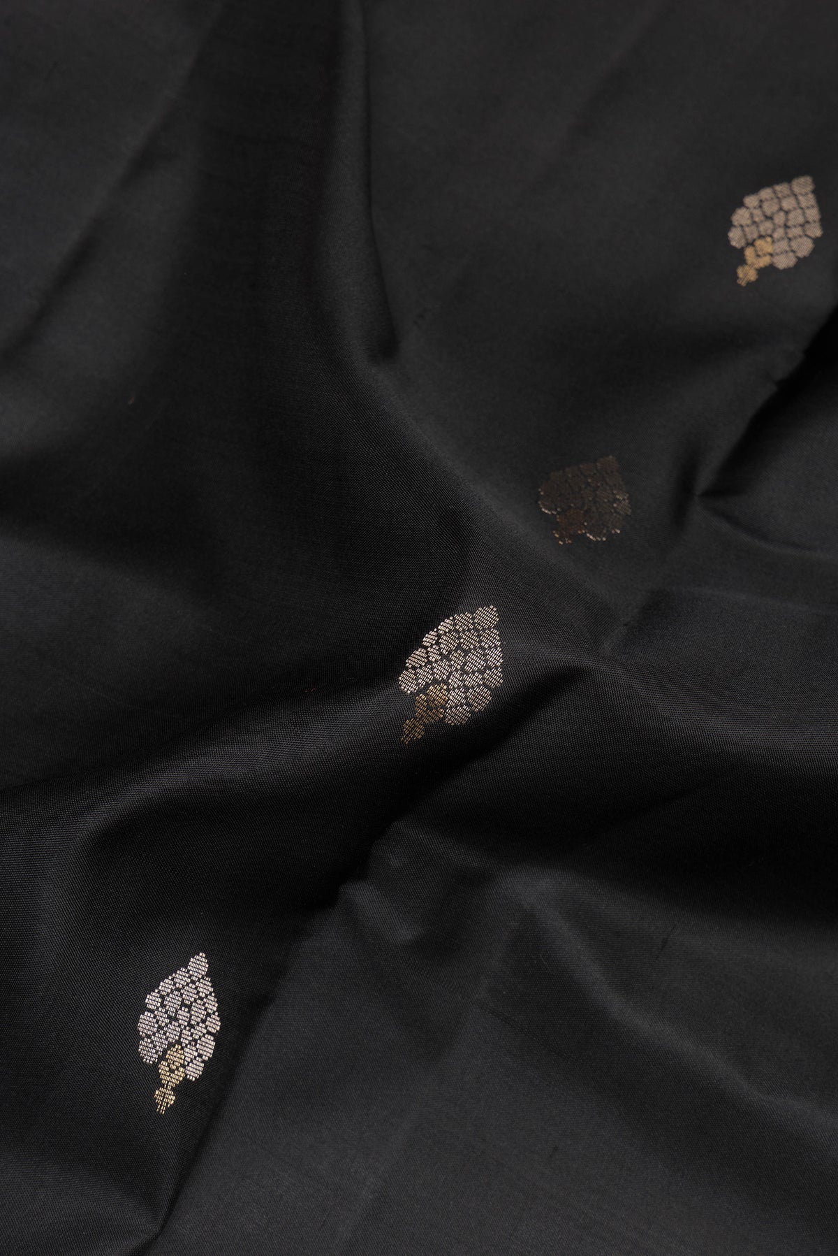 Close up of Pure Silk Black Dual Tone Soft Saree with Zari Butta on the body and Zari Border.  displaying folds