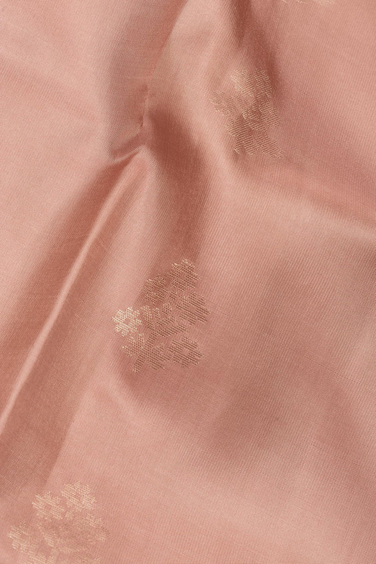 Close up of Pure Silk Rose Gold Dual Tone Soft Saree with Zari Butta on the body and Zari Border.  displaying folds