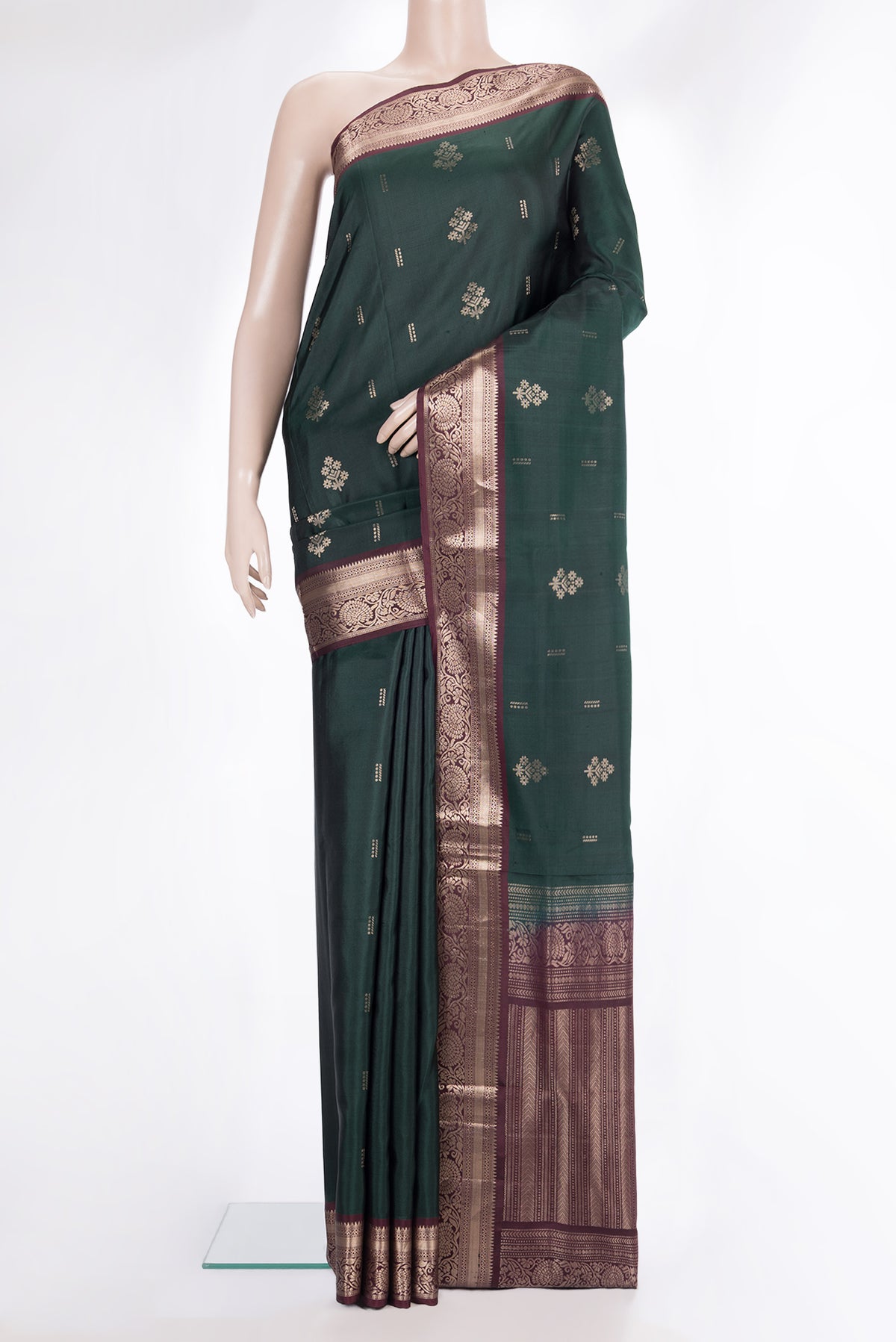 Pure Silk Bottle Green Soft Saree with Zari Butta on the body and Zari Border.  displayed on a mannequin