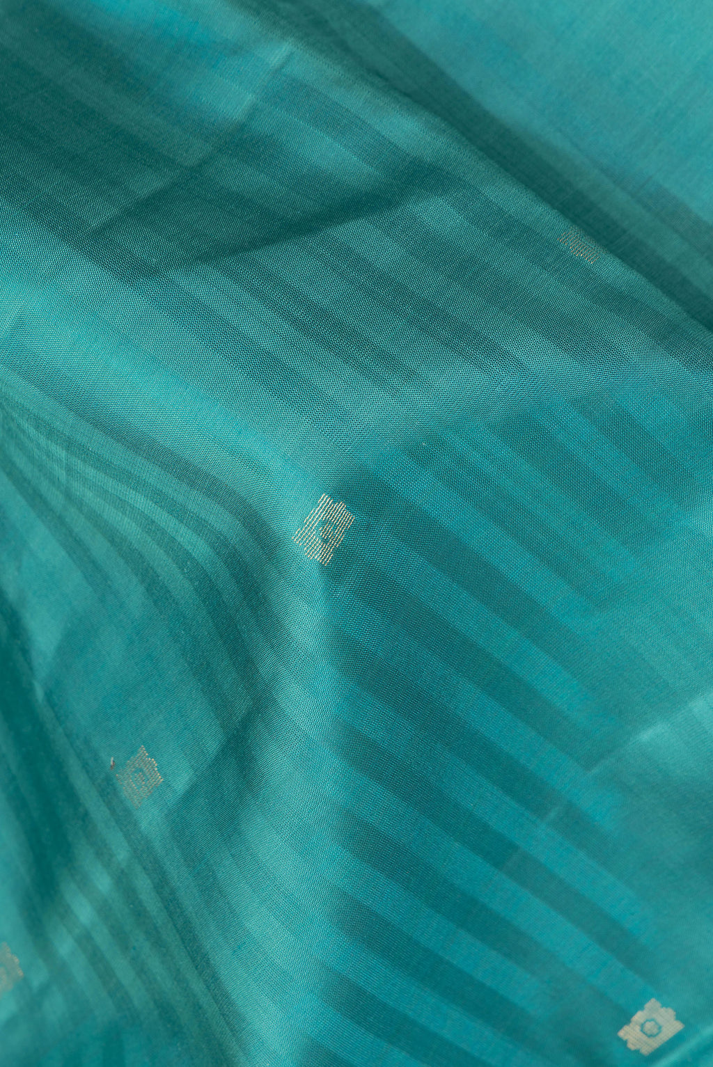 Close up of Pure Silk Peacock Blue Dual Tone Soft Saree with Zari Butta on the body and Fancy Border.  displaying folds