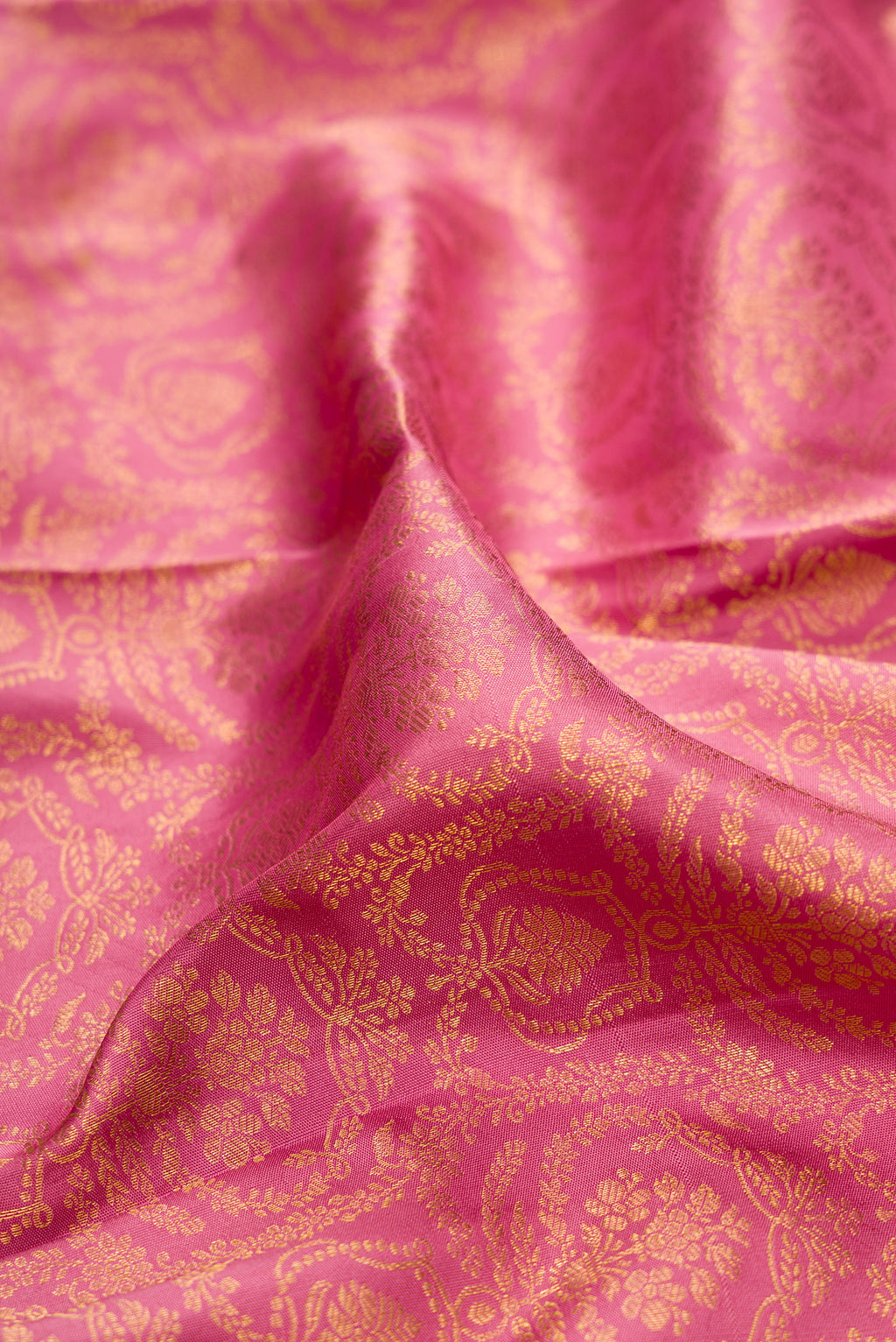 Close up of Pure Silk Rose pink Kanjivaram Saree with Zari Brocade on the body and Zari Border.  displaying folds