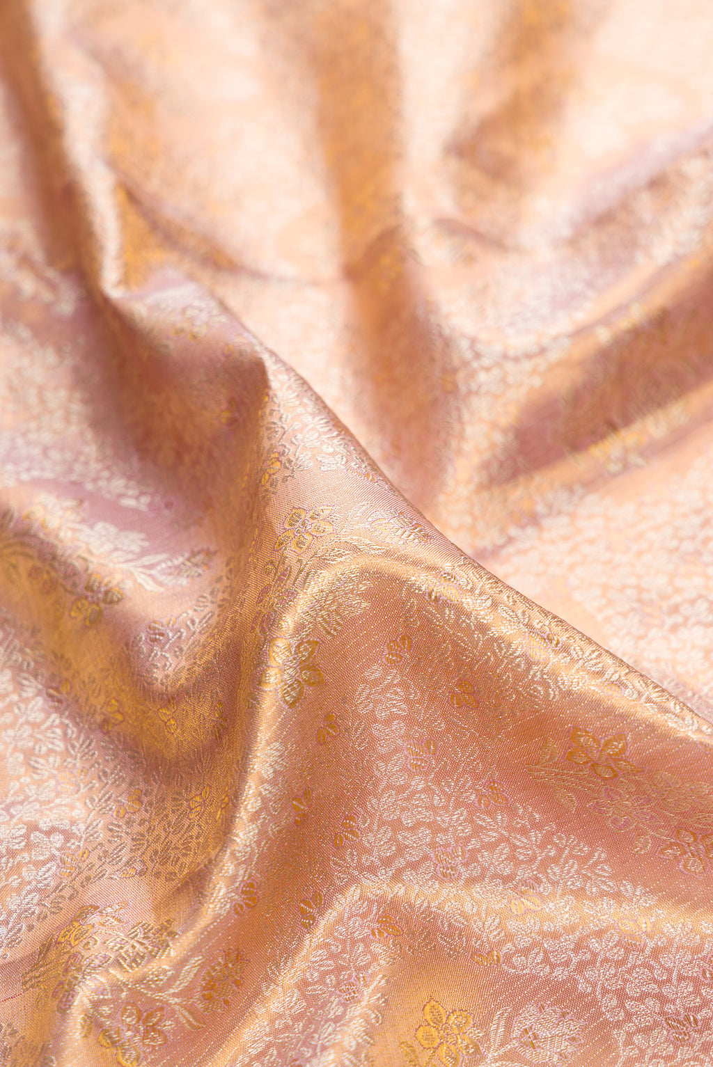 Close up of Rose Gold Dual Tone Kanchipuram Tissue Saree with Zari Brocade on the body and Fancy Border.  displaying folds