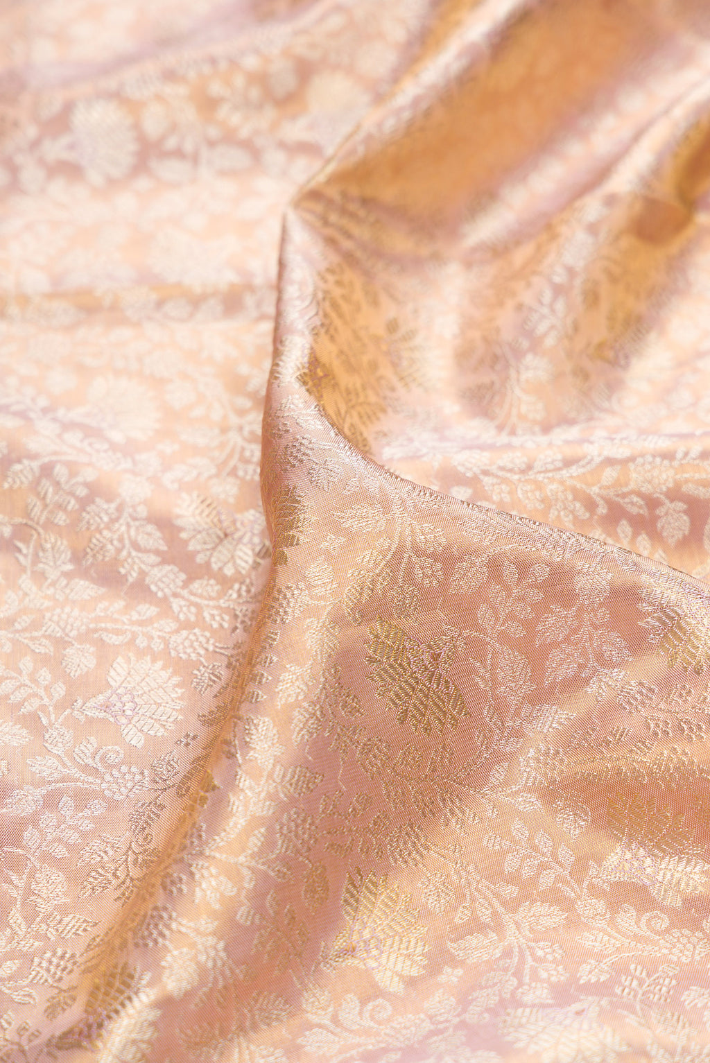 Close up of Rose Gold Dual Tone Kanchipuram Tissue Saree with Zari Brocade on the body and Fancy Border.  displaying folds