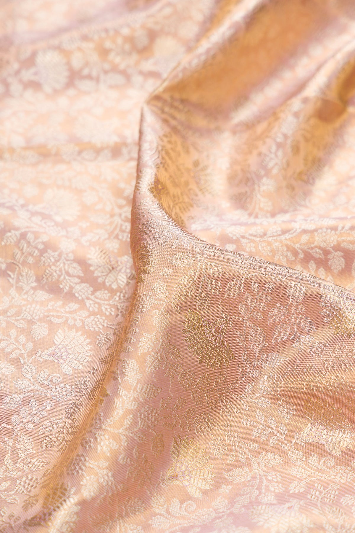 Close up of Rose Gold Dual Tone Kanchipuram Tissue Saree with Zari Brocade on the body and Fancy Border.  displaying folds