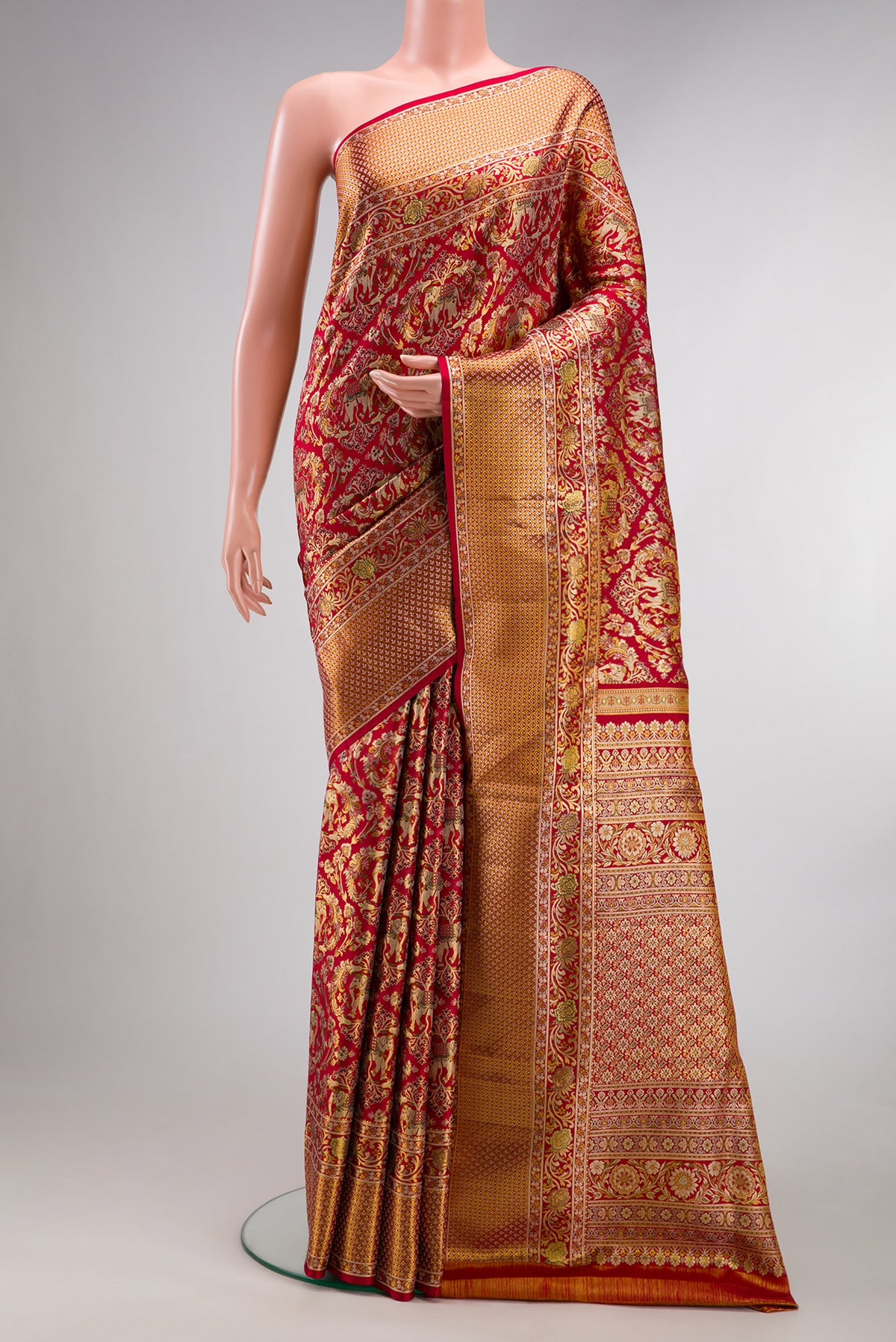 Deep Red Dual Tone Kanchipuram Tissue Saree with Zari Brocade on the body and Fancy Border.  displayed on a mannequin