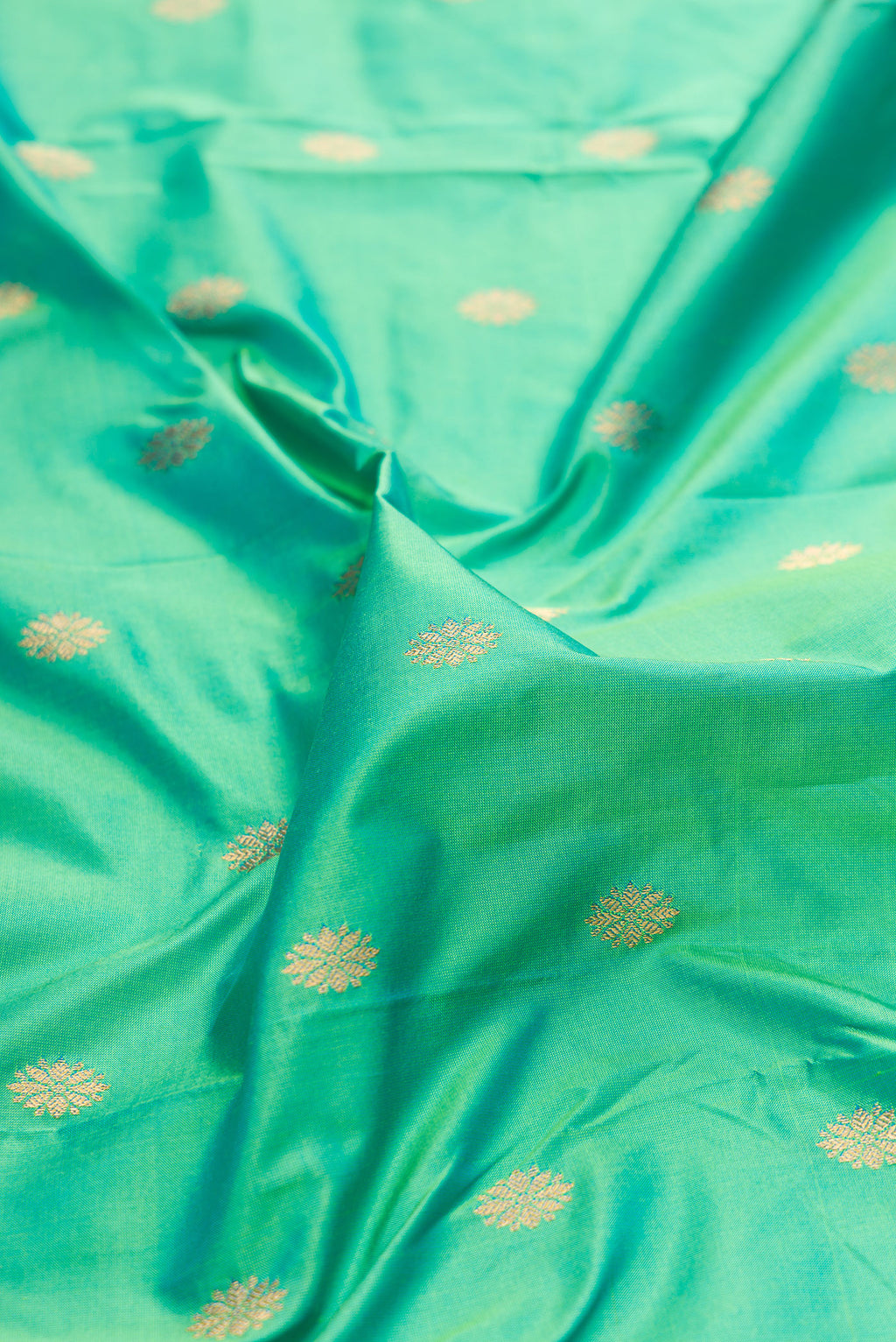 Close up of Pure Silk Sea Green Paithani Saree with Zari Butta on the body and Paithani Border.  displaying folds