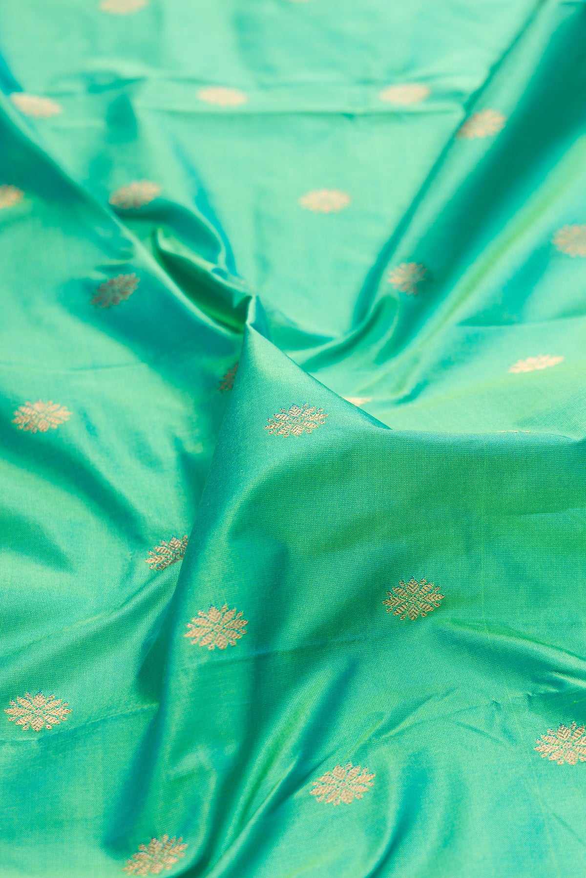 Close up of Pure Silk Sea Green Paithani Saree with Zari Butta on the body and Paithani Border.  displaying folds