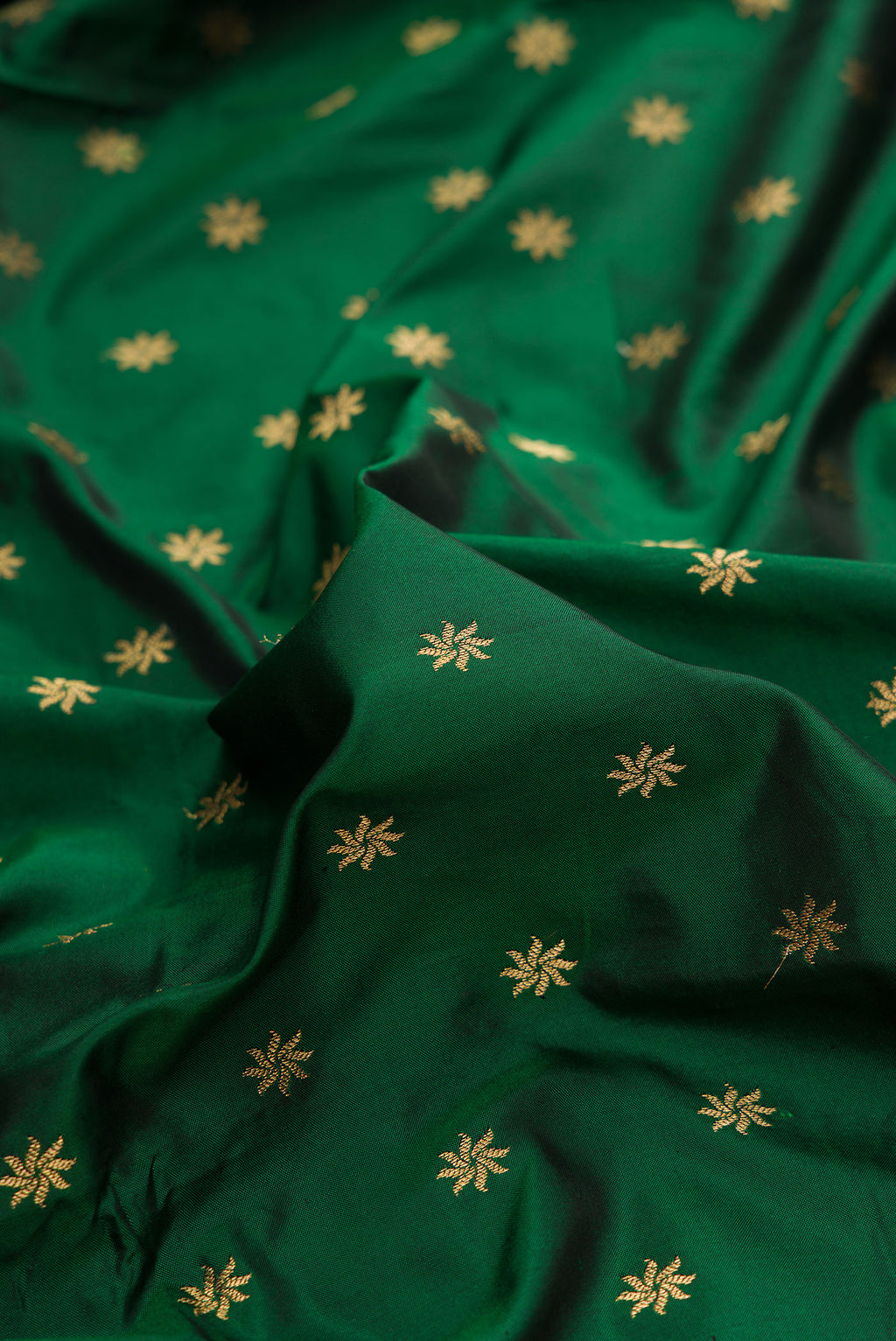 Close up of Pure Silk Bottle Green Paithani Saree with Zari Butta on the body and Paithani Border.  displaying folds