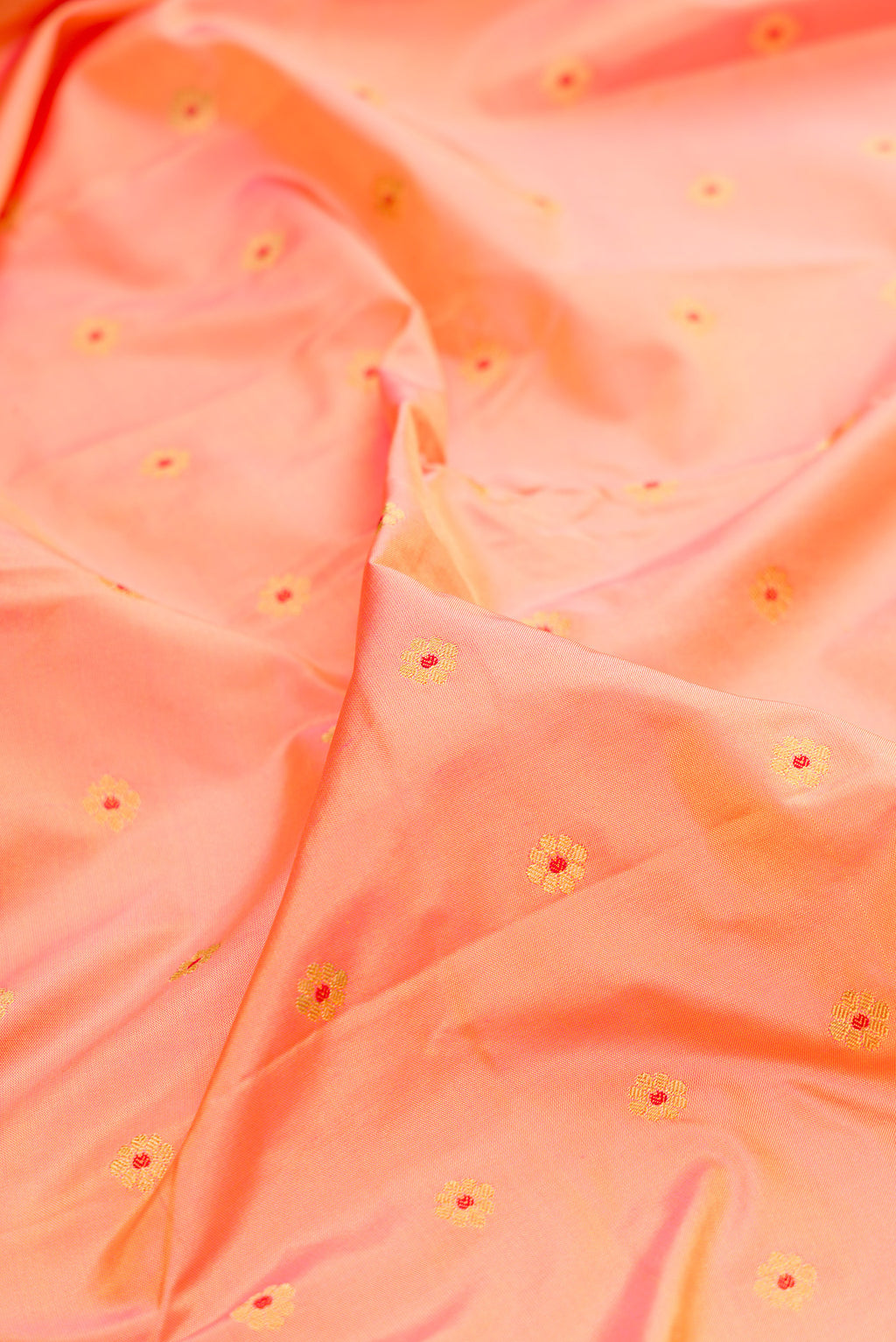 Close up of Pure Silk Peach Dual Tone Paithani Saree with Zari Butta on the body and Paithani Border.  displaying folds