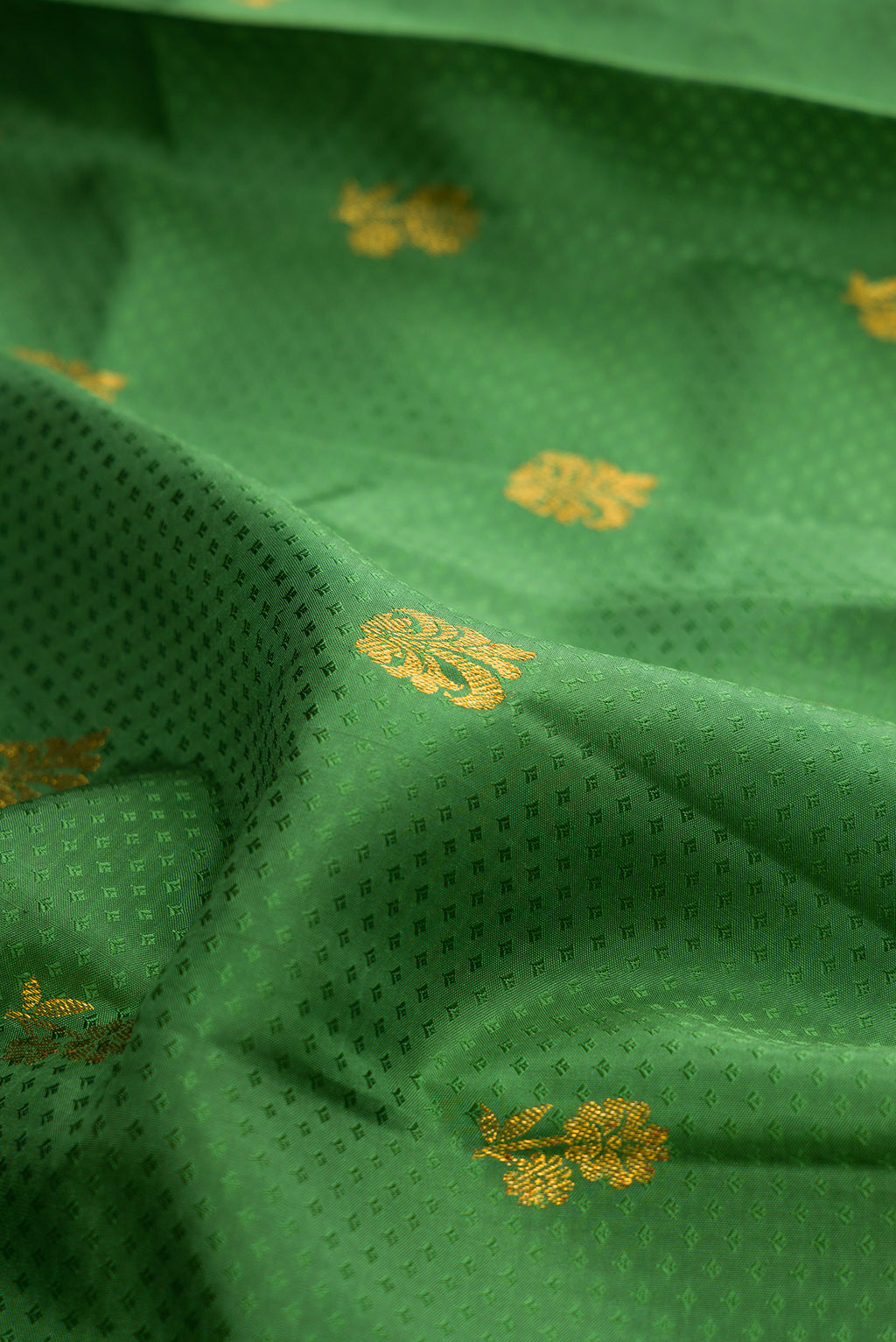 Close up of Pure Silk Green Kanjivaram Saree with Jacquard design on the body and Zari Border.  displaying folds
