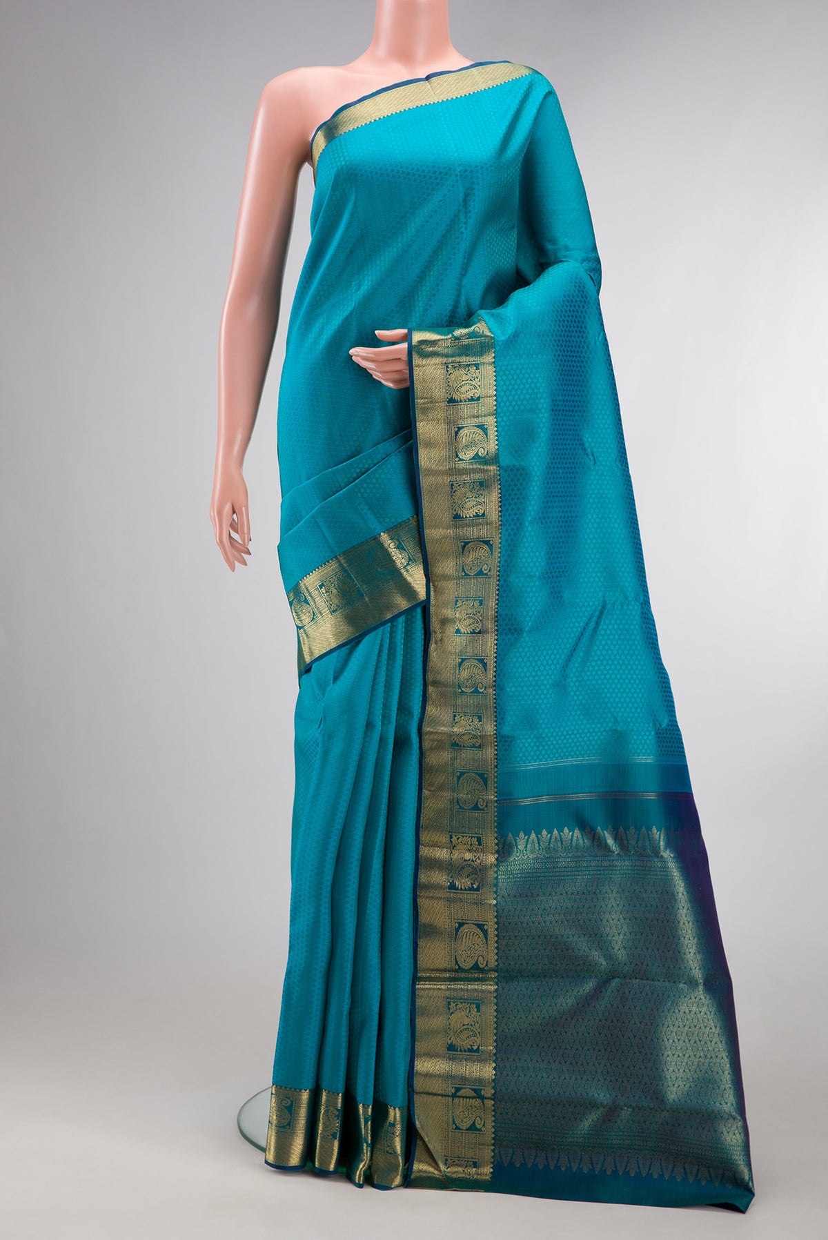 Pure Silk Peacock Blue Kanchipuram Saree with Jacquard design on the body and Zari Border.  displayed on a mannequin