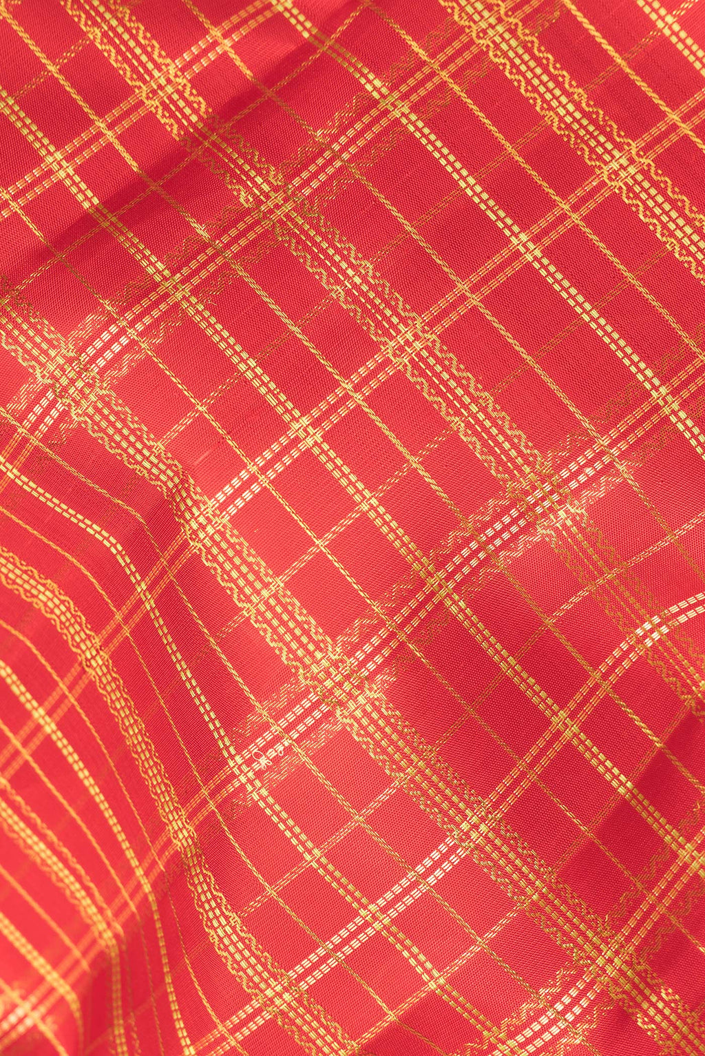 Close up of Pure Silk Red Kanchipuram Saree with Checked design on the body and Zari Border.  displaying folds