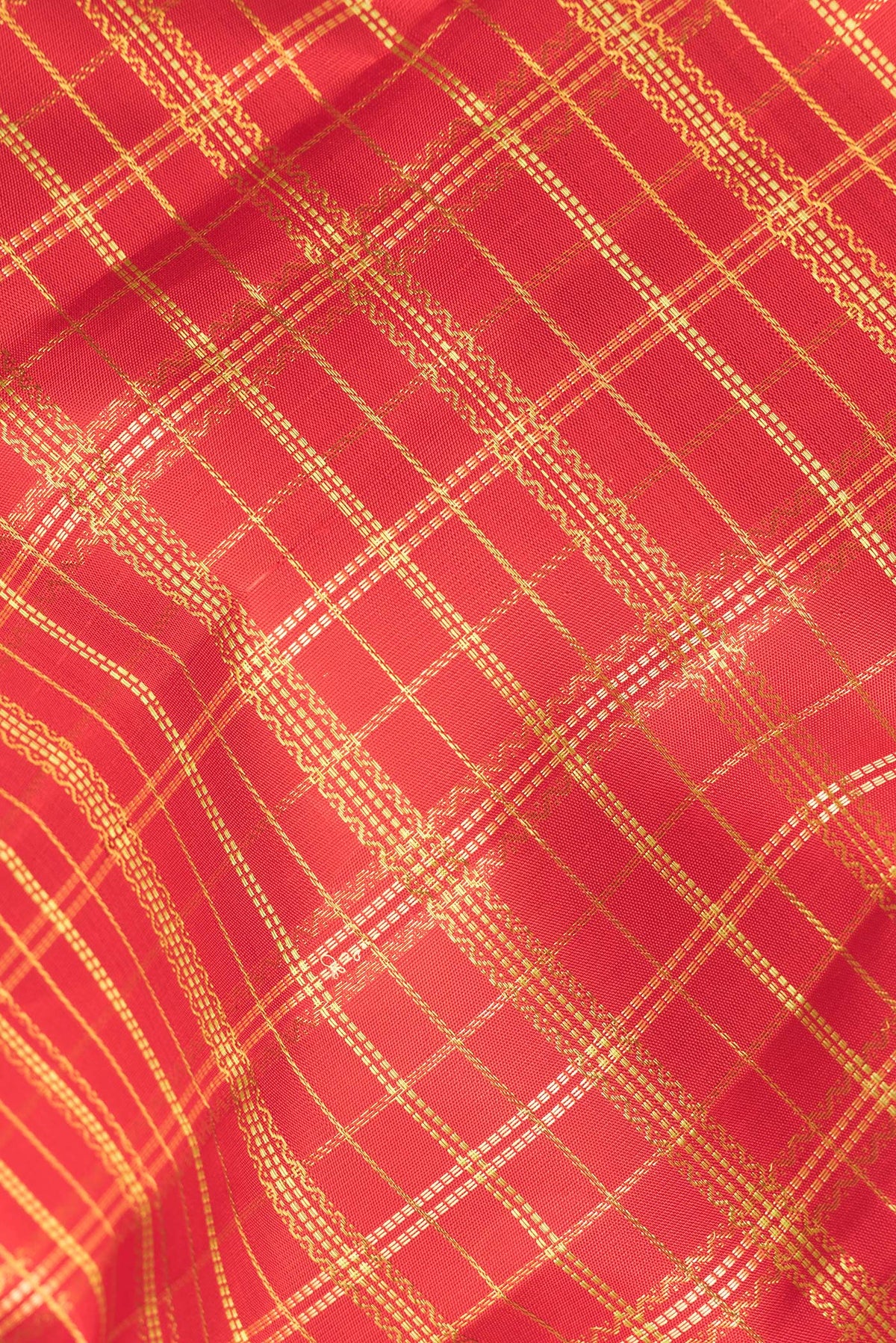 Close up of Pure Silk Red Kanchipuram Saree with Checked design on the body and Zari Border.  displaying folds