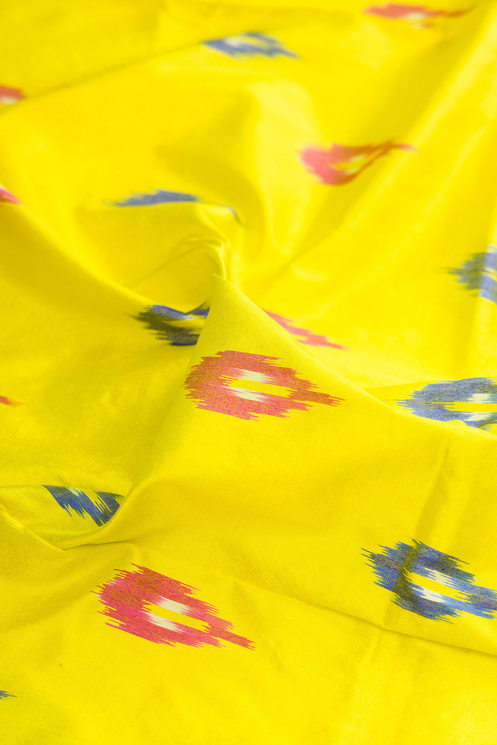 Close up of Pure Silk Lemon Yellow Pochampally Saree with Ikat design on the body and Ikat Border.  displaying folds