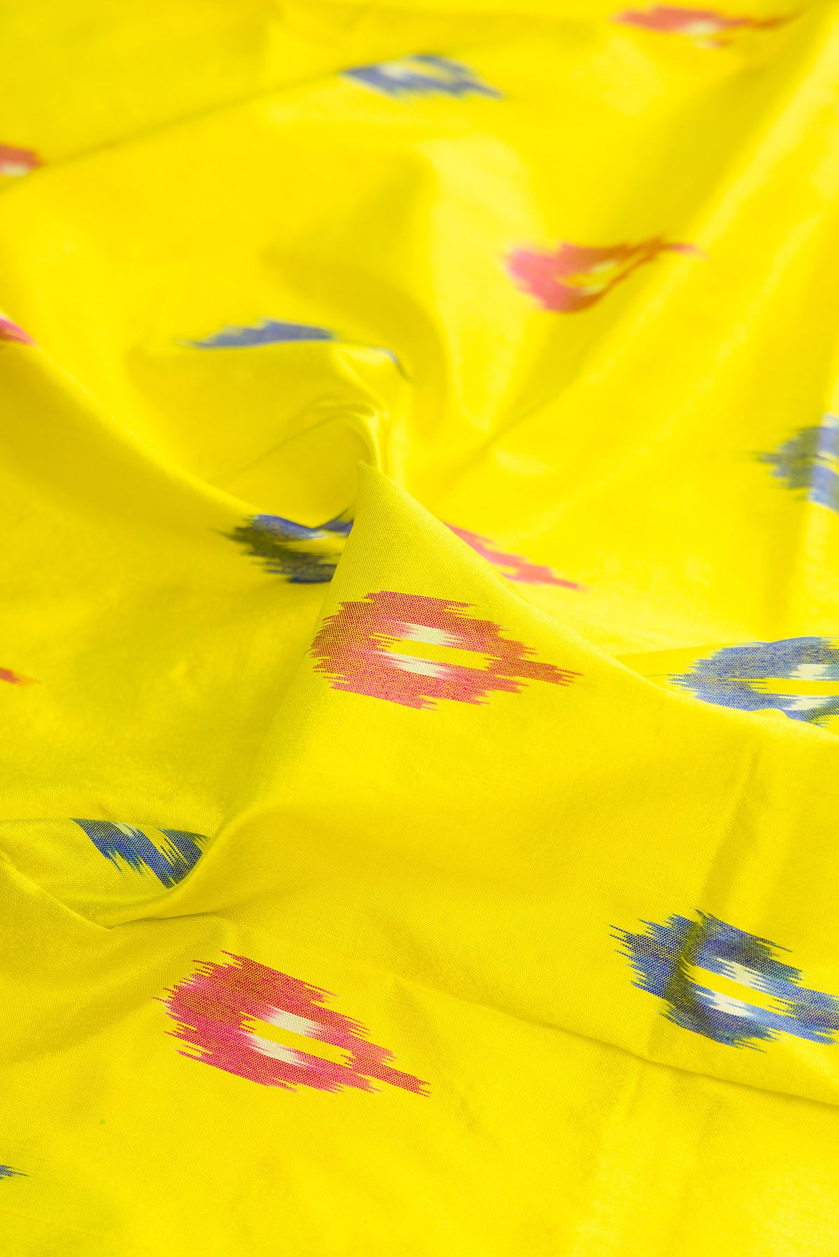 Close up of Pure Silk Lemon Yellow Pochampally Saree with Ikat design on the body and Ikat Border.  displaying folds