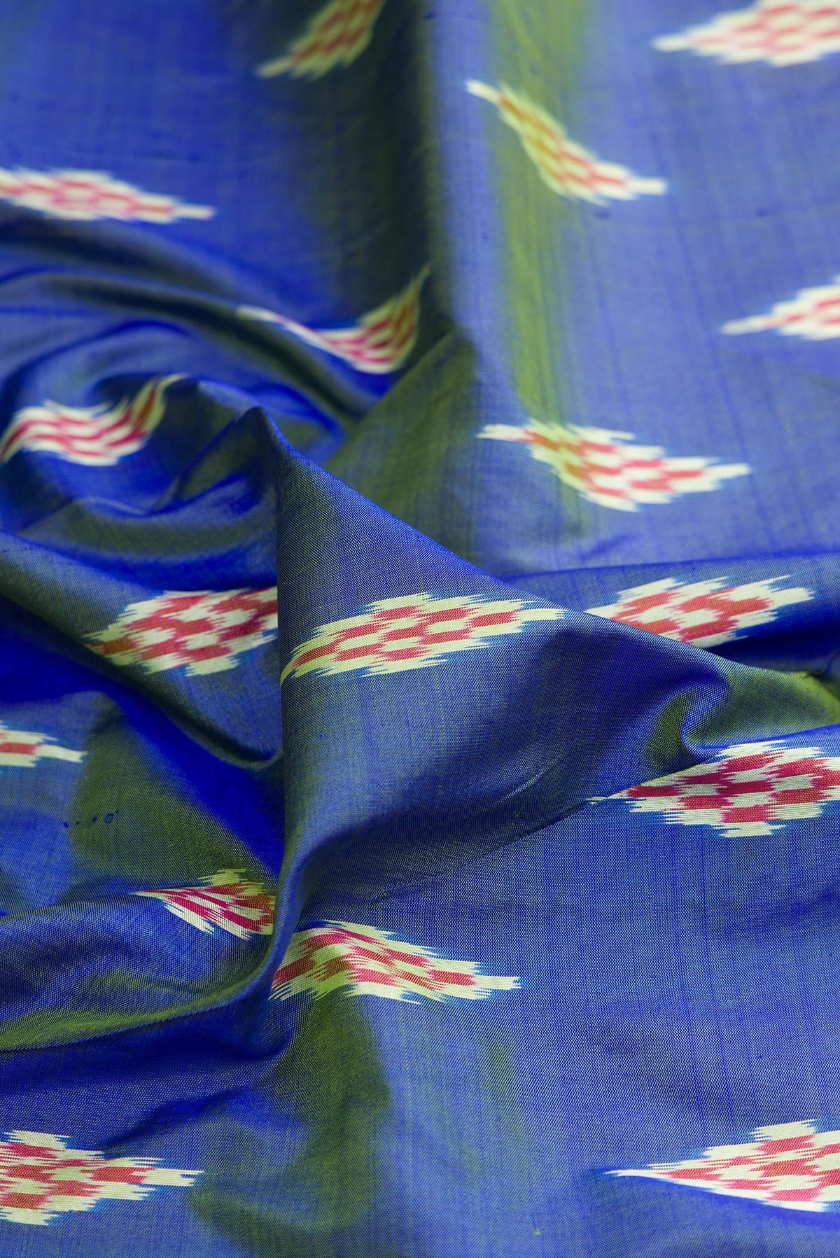 Close up of Pure Silk Maya Blue Dual Tone Pochampally Saree with Ikat design on the body and Ikat Border.  displaying folds