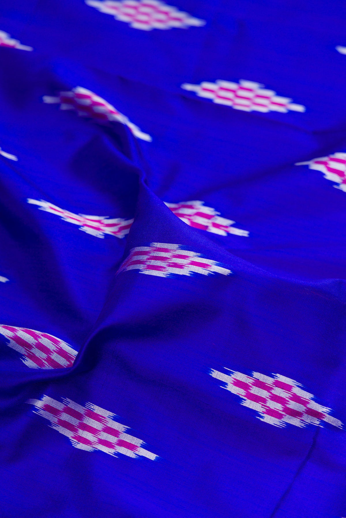 Close up of Pure Silk Royal Blue Dual Tone Pochampally Saree with Ikat design on the body and Ikat Border.  displaying folds