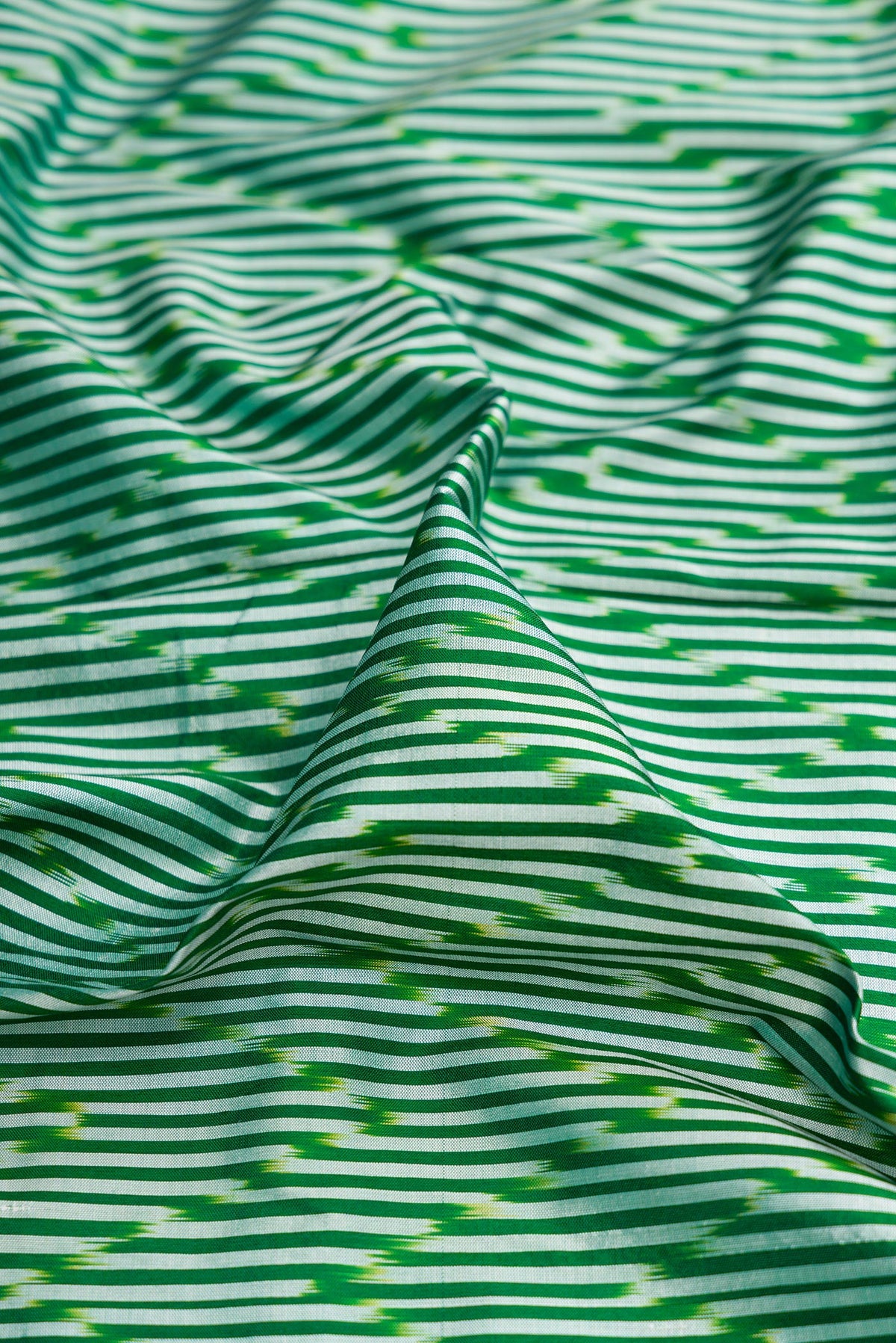 Close up of Pure Silk Green Pochampally Saree with Ikat design on the body and Ikat Border.  displaying folds