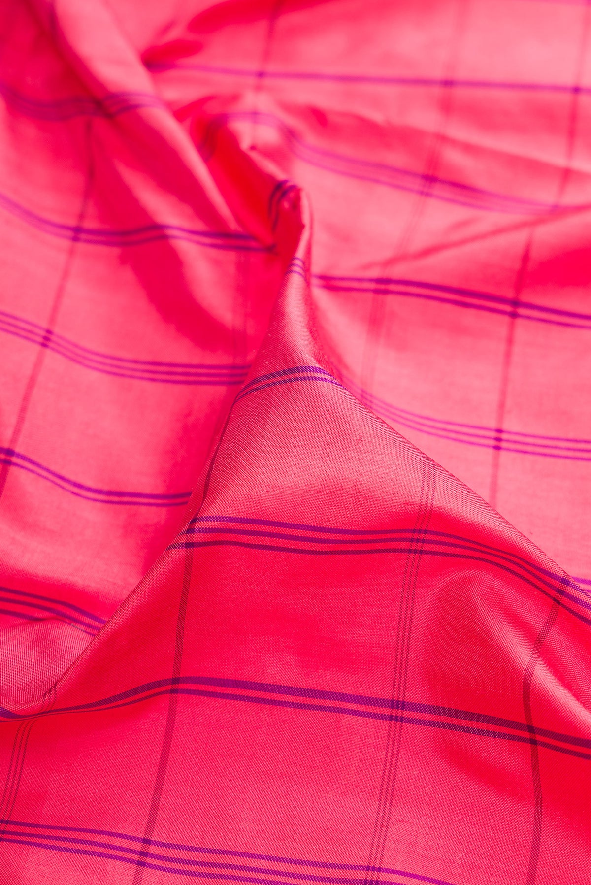 Close up of Pure Silk Coral Pochampally Saree with Checked design on the body and Temple Border.  displaying folds