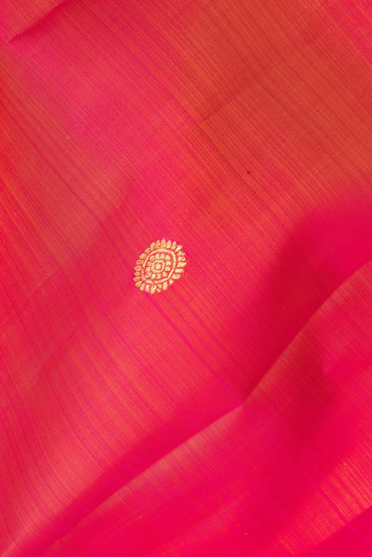 Close up of Pure Silk Coral Dual Tone Kanjivaram Saree with Zari Butta on the body and Plain Border.  displaying folds