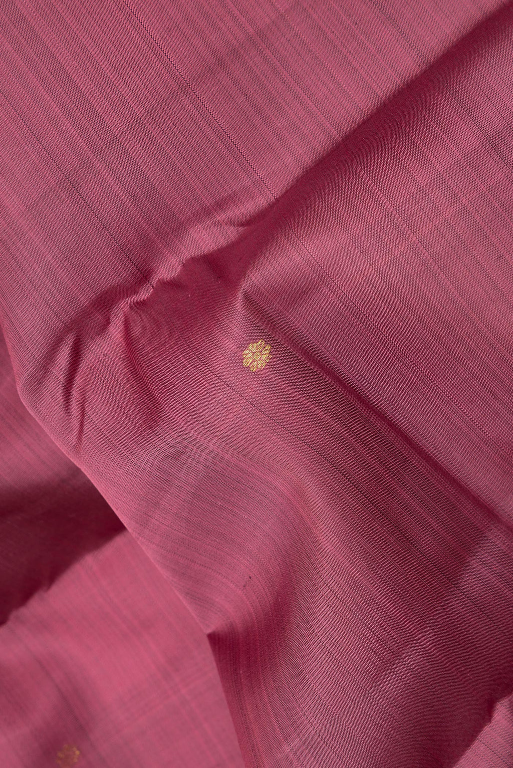 Close up of Pure Silk Coral Kanjivaram Saree with Zari Butta on the body and Zari Border.  displaying folds