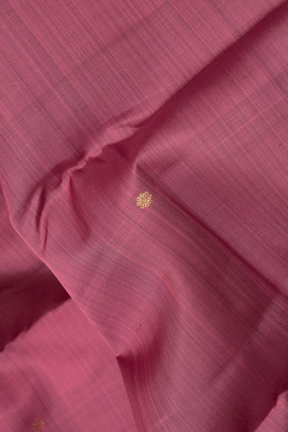 Close up of Pure Silk Coral Kanjivaram Saree with Zari Butta on the body and Zari Border.  displaying folds