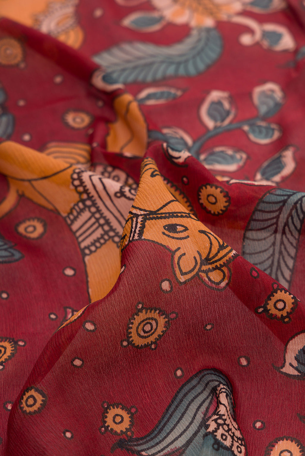 Close up of Maroon Mysore Chiffon Saree with kalamkari Print on the body and Zari Border.  displaying folds
