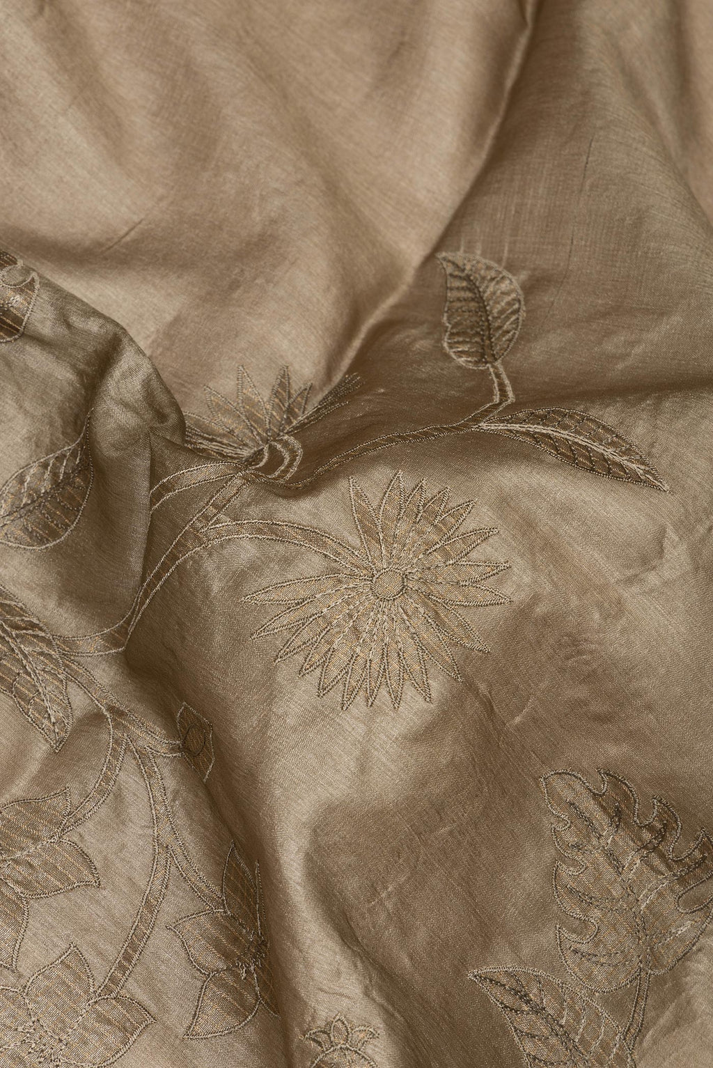 Close up of Brown Tussar Saree with Embroidery on the body and Embroidery Border.  displaying folds