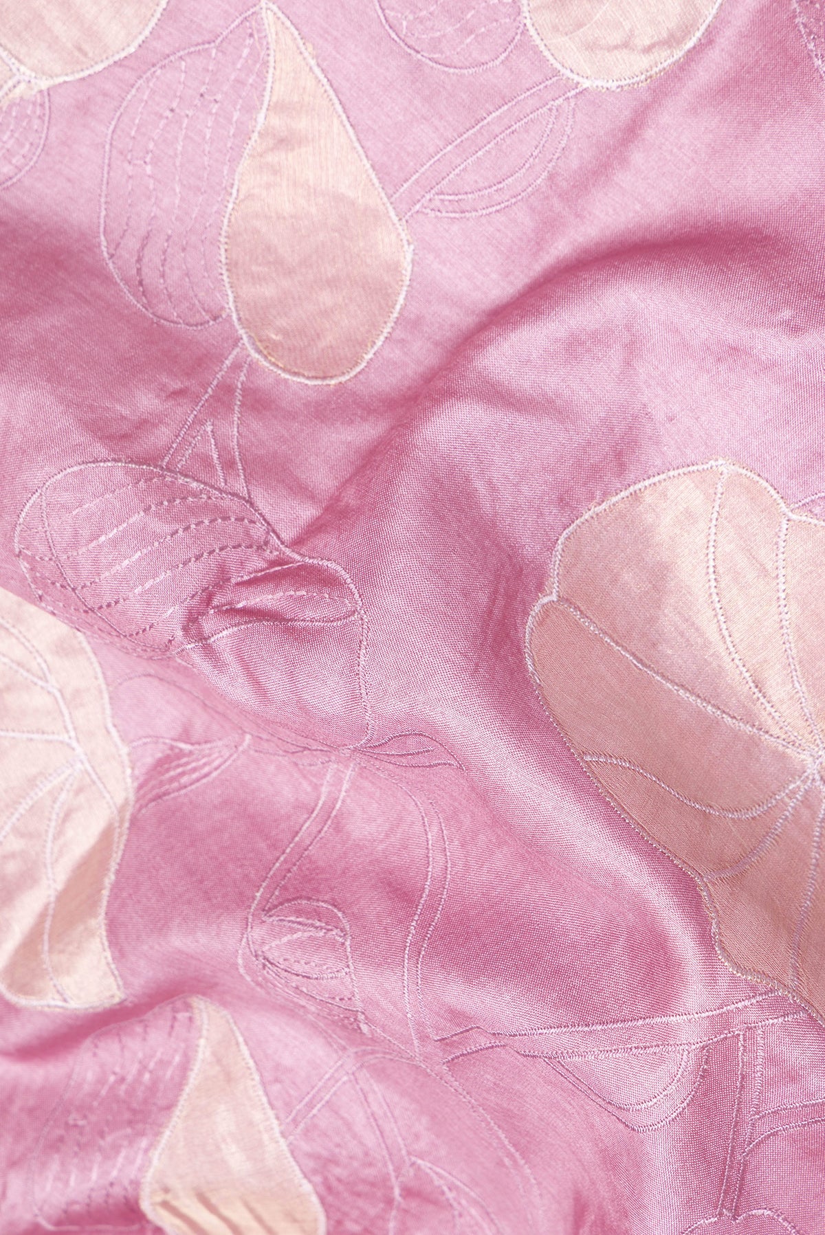 Close up of Rose Gold Tussar Saree with Embroidery on the body and Embroidery Border.  displaying folds