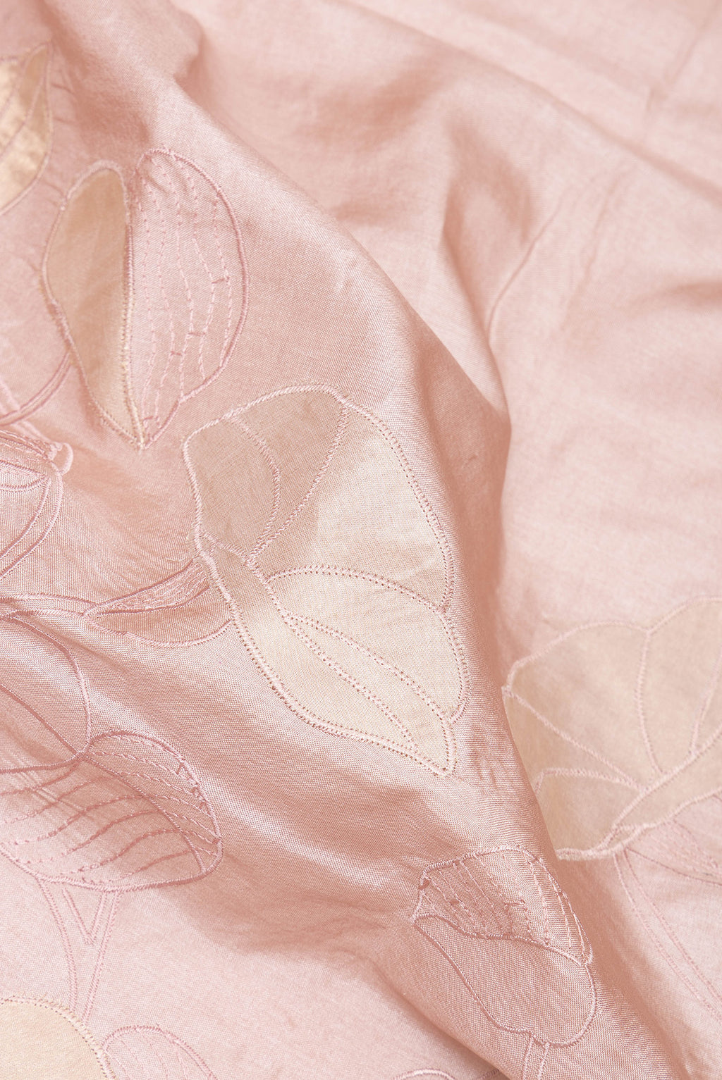 Close up of Rose Gold Tussar Saree with Embroidery on the body and Embroidery Border.  displaying folds