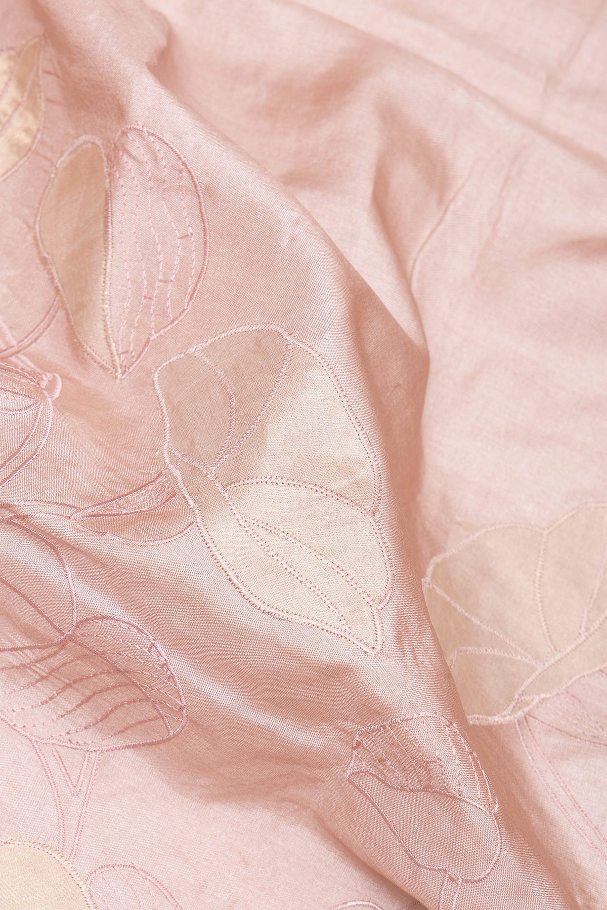 Close up of Rose Gold Tussar Saree with Embroidery on the body and Embroidery Border.  displaying folds