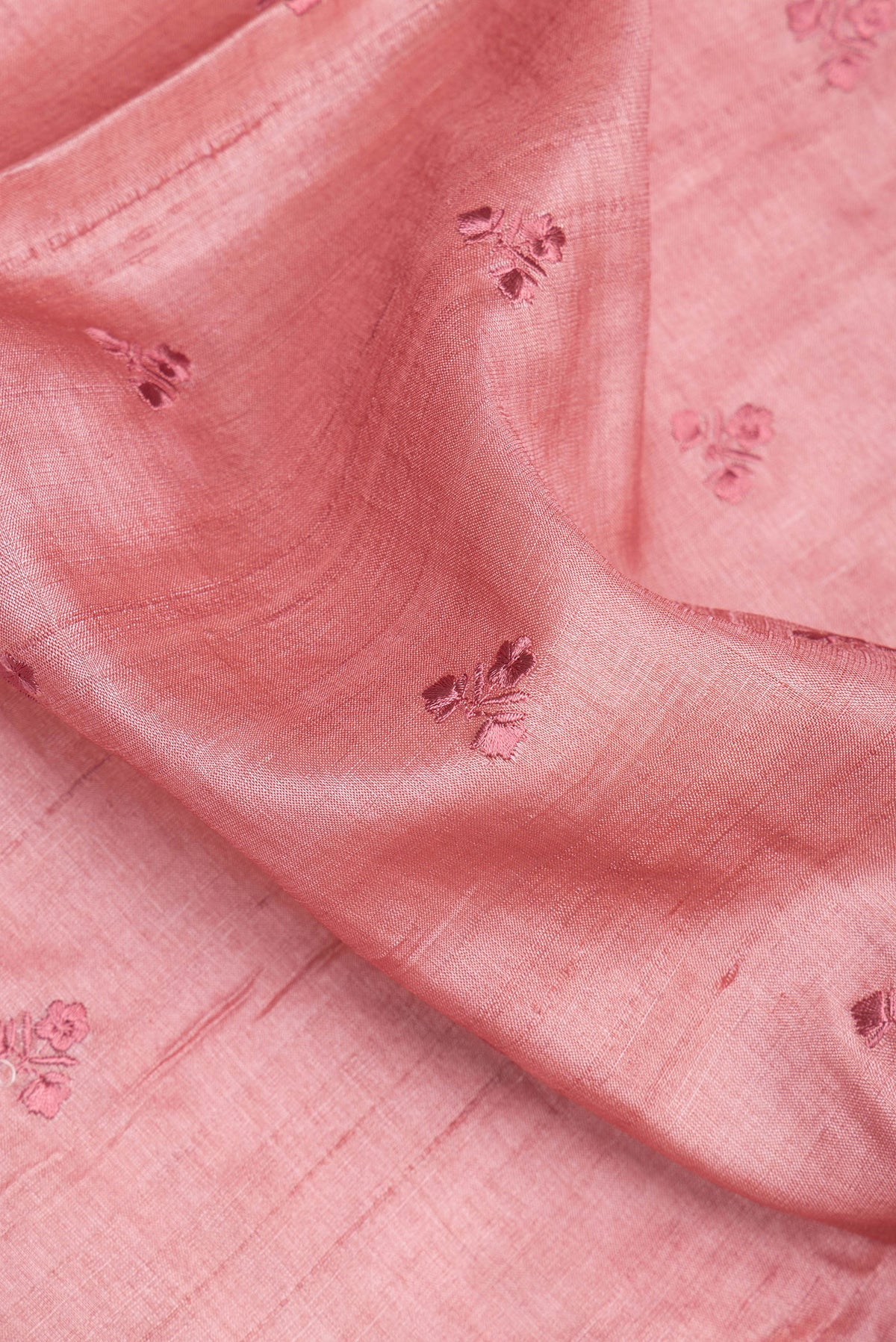 Close up of Peach Tussar Saree with Embroidery on the body and Embroidery Border.  displaying folds