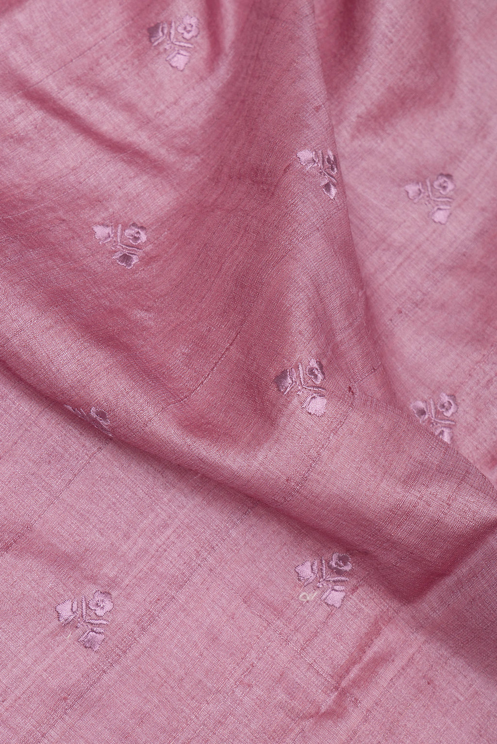 Close up of Rose Gold Tussar Saree with Embroidery on the body and Embroidery Border.  displaying folds