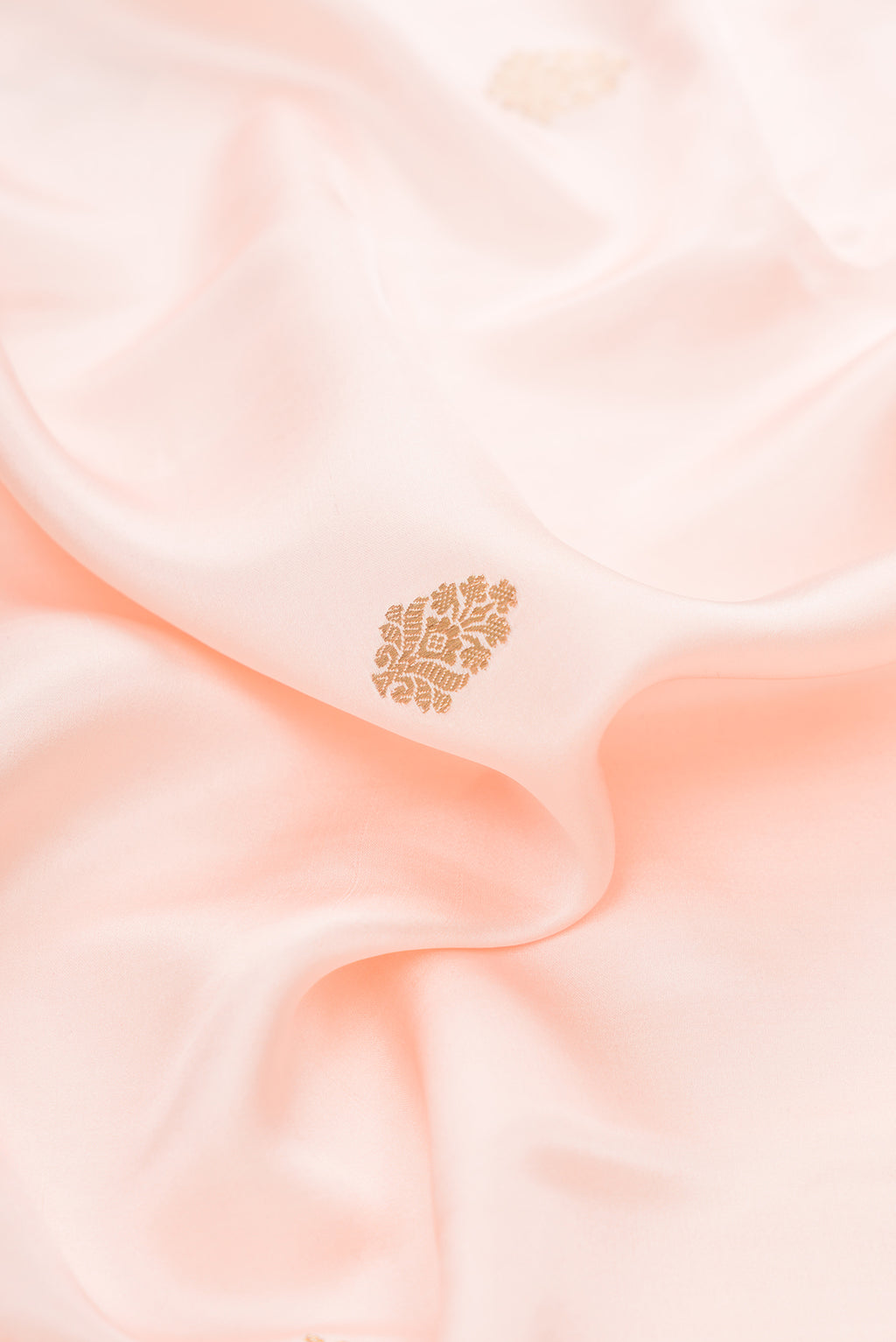 Close up of Pure Silk Peach Dual Tone Banarasi Saree with Zari Butta on the body and Fancy Border.  displaying folds