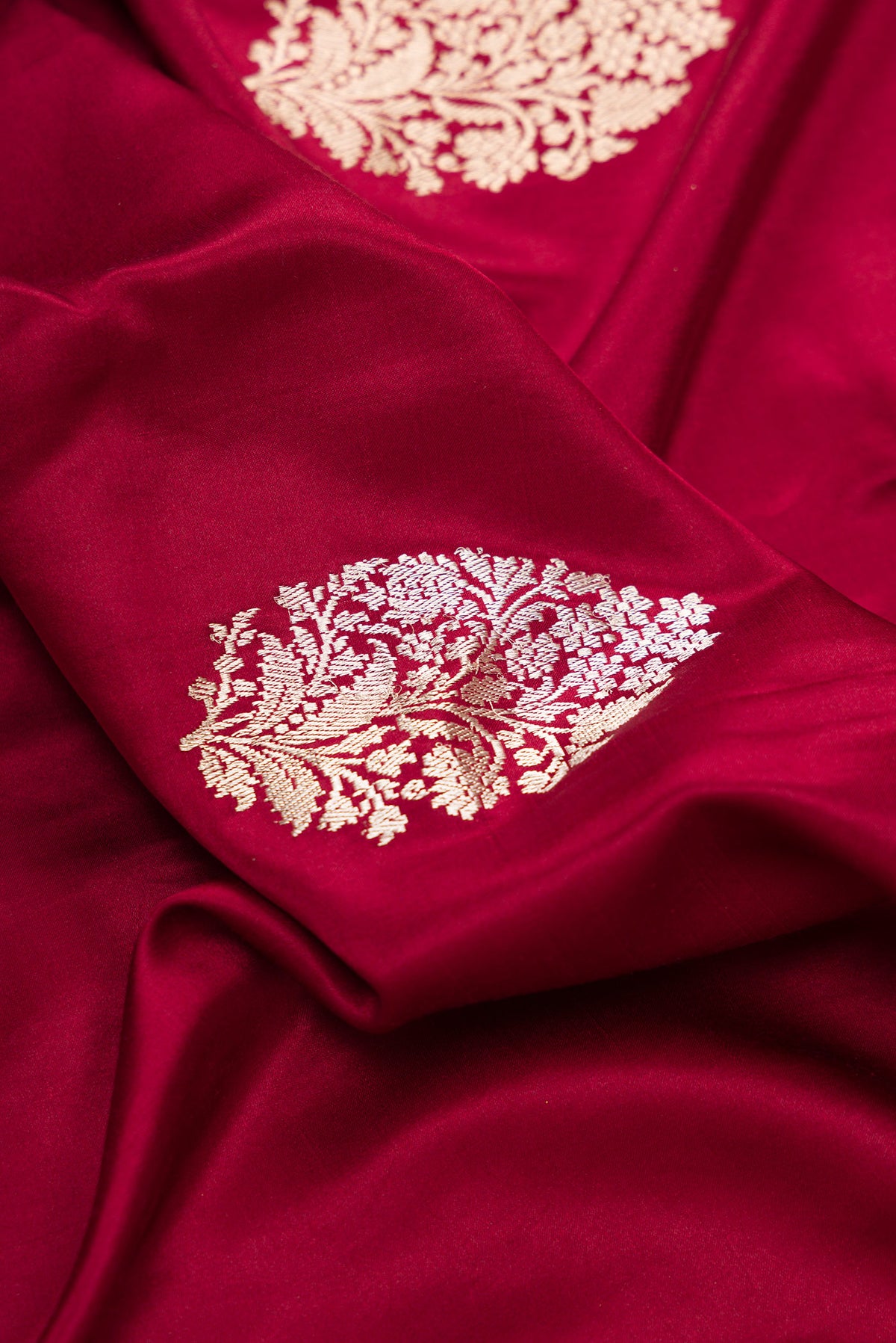 Close up of Pure Silk Maroon Dual Tone Banarasi Saree with Zari Butta on the body and Zari Border.  displaying folds