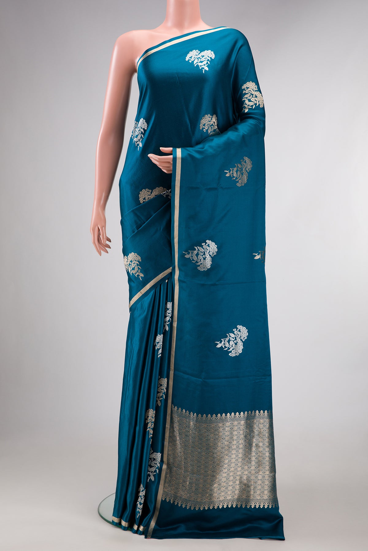 Pure Silk Peacock Blue Dual Tone Banarasi Saree with Zari Butta on the body and Zari Border.  displayed on a mannequin