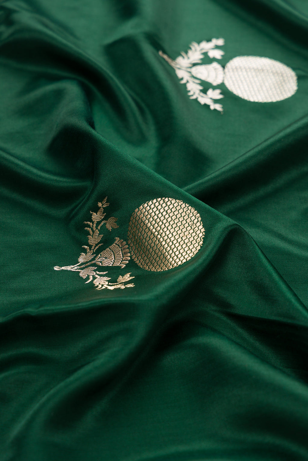 Close up of Pure Silk Bottle Green Banarasi Saree with Zari Butta on the body and Zari Border.  displaying folds